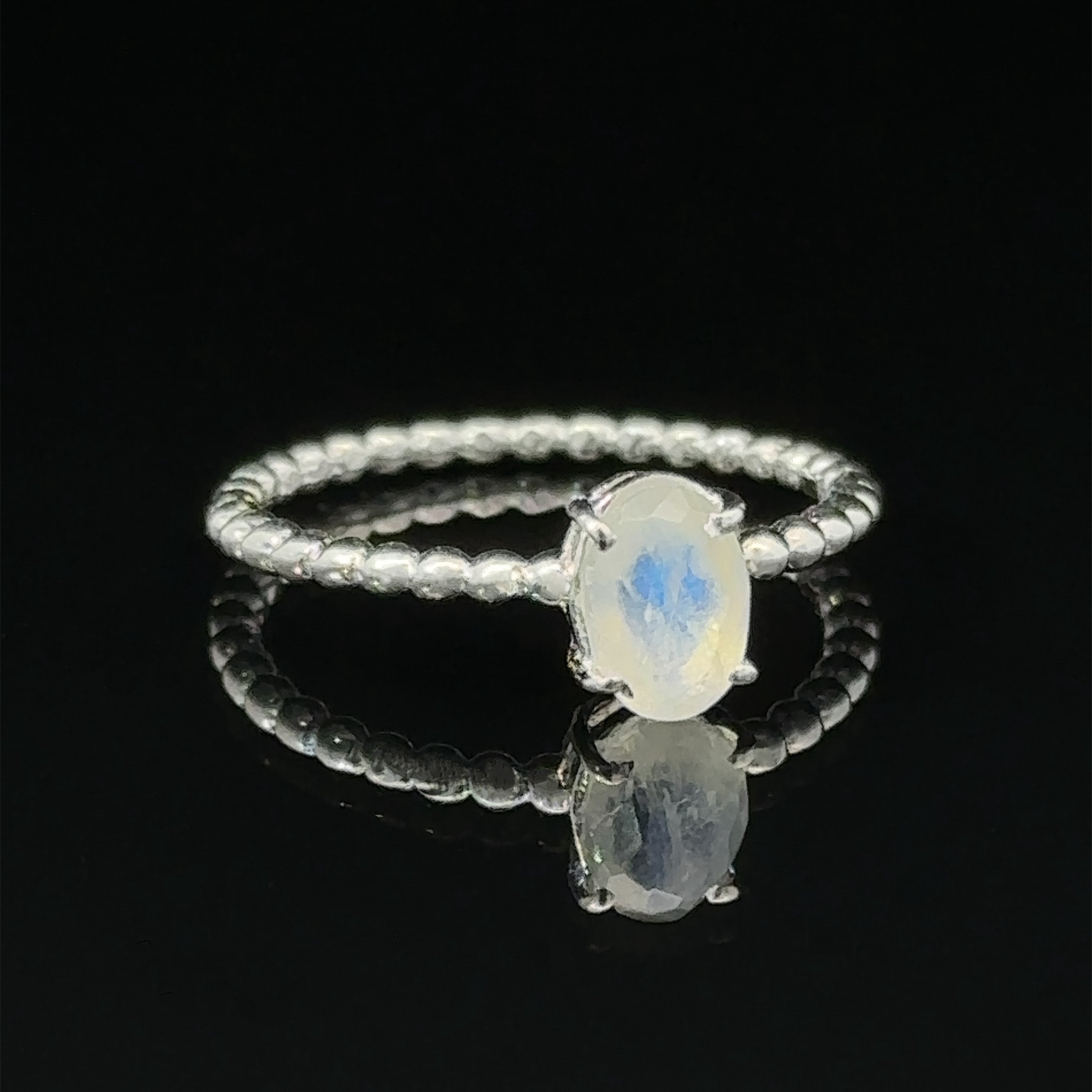 Stunning Oval Gemstone Ring with Beaded Band with an oval amethyst set on a black background.