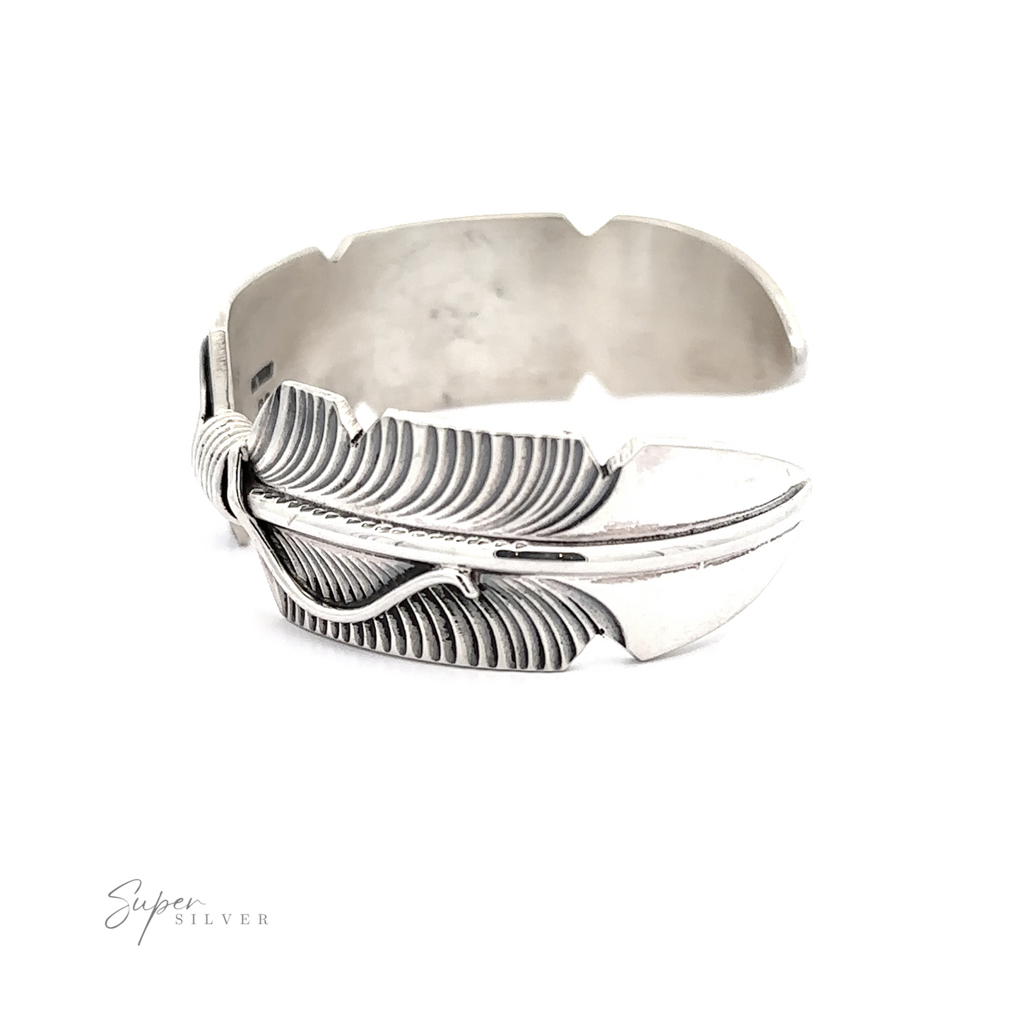 
                  
                    A Native American silver feather cuff bracelet displayed on a white background with a reflective surface.
                  
                