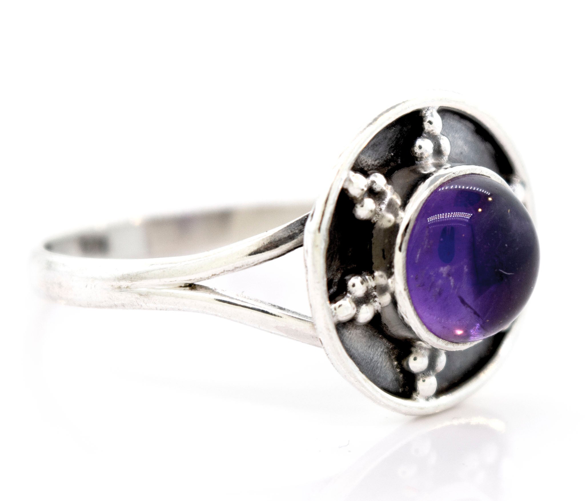 A Gemstone Ring With Unique Oxidized Design featuring a round, polished purple gemstone set in the center of a circular, detailed design that showcases the beauty of oxidized silver.