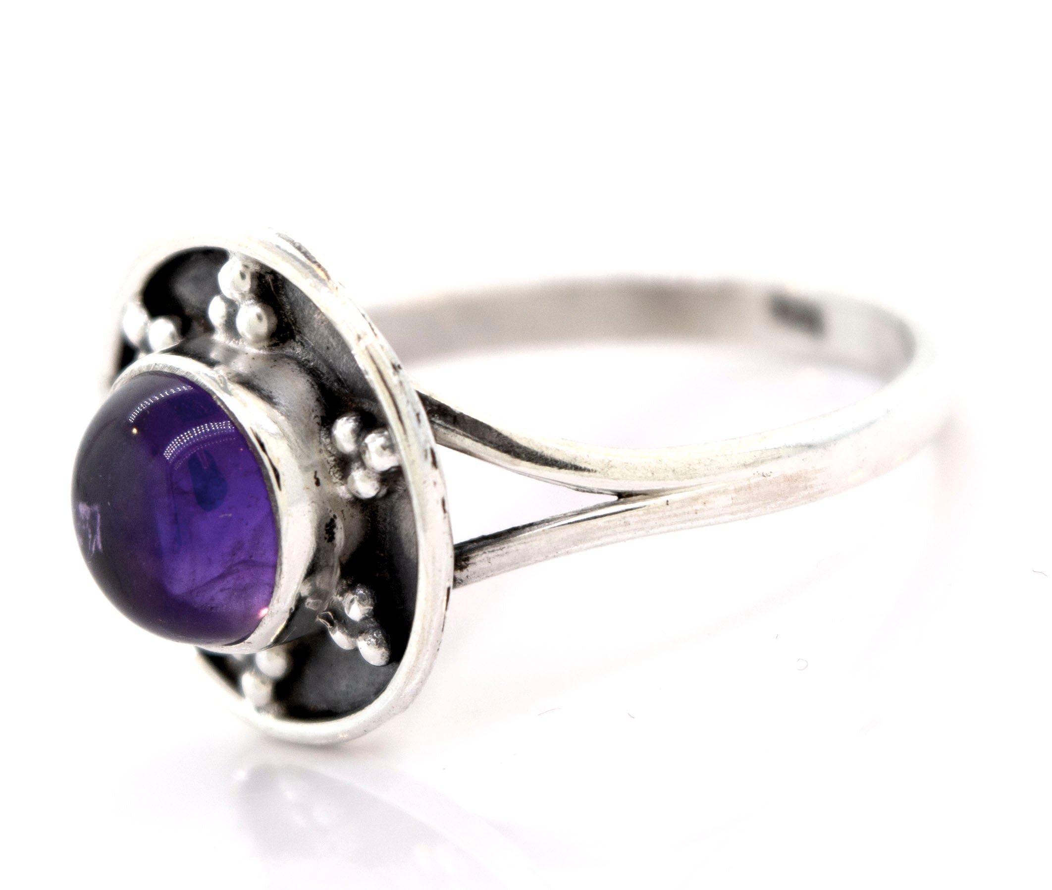 A Gemstone Ring With Unique Oxidized Design featuring a round purple gemstone set in a decorative bezel, exemplifying the elegance of gemstone jewelry in stunning sterling silver.