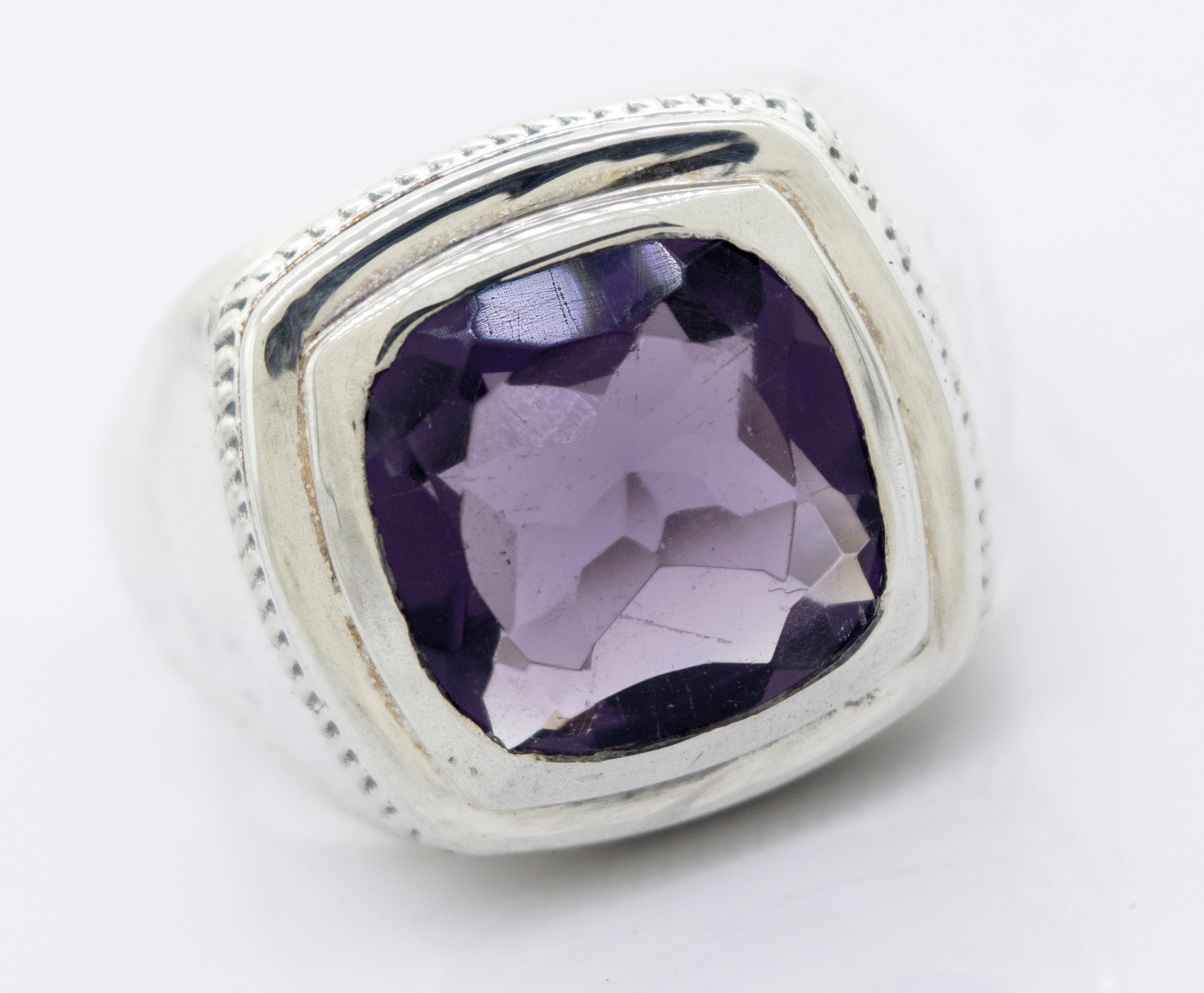 A Faceted Stone Signet Ring with a large, square-cut Amethyst gemstone set in the center.