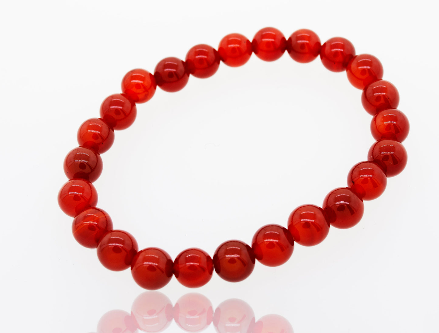 
                  
                    A circular red 4mm Beaded Stone Bracelet on a white background with a reflective surface.
                  
                