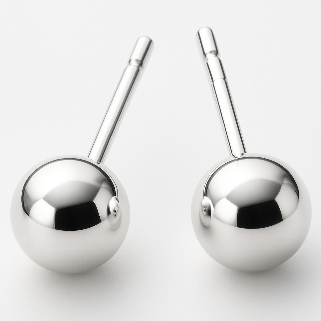 Two shiny Simple Silver Ball Studs, featuring metallic spherical designs with short cylindrical handles, stand upright on a white background—an everyday essential in modern design.