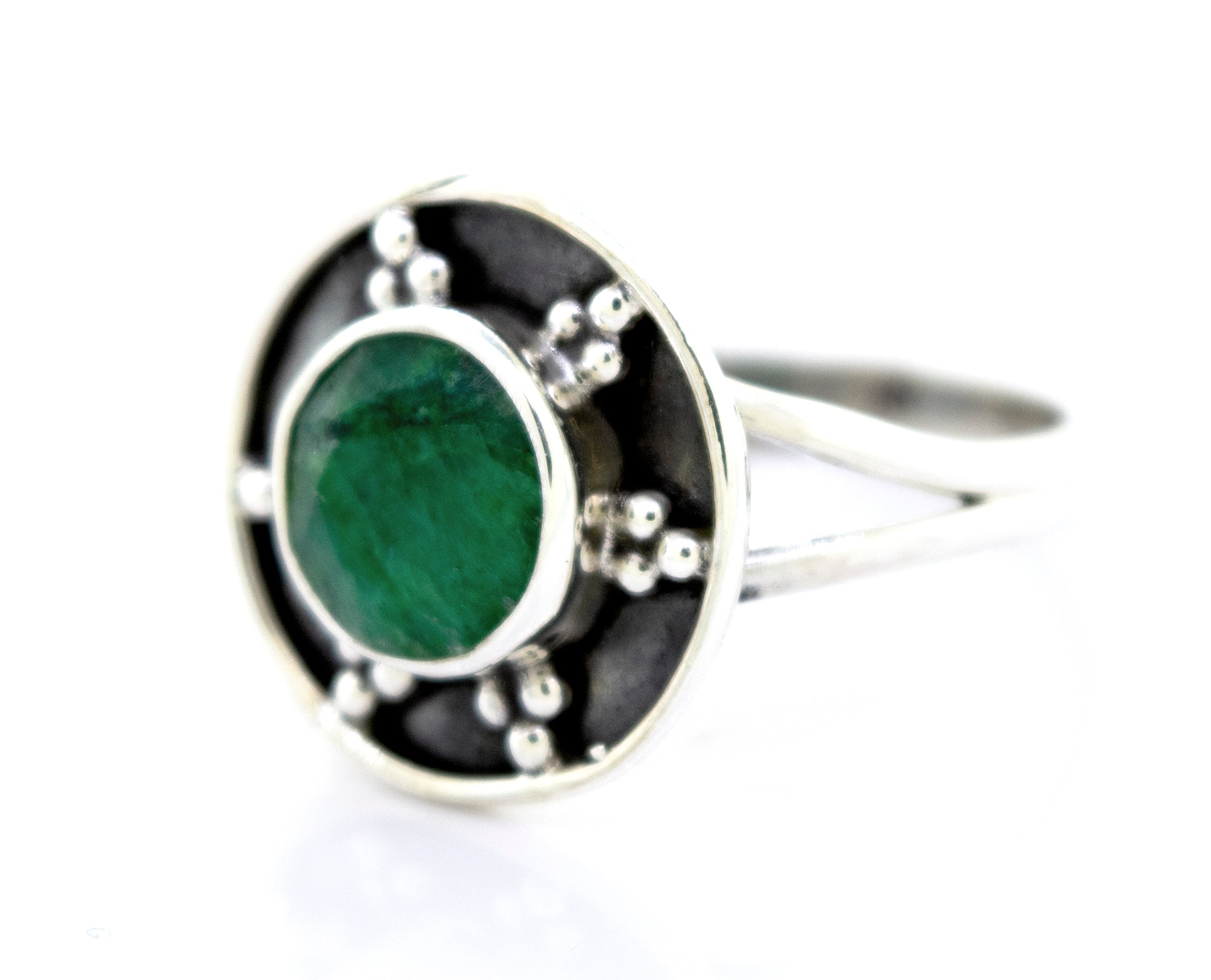 A Gemstone Ring With Unique Oxidized Design featuring a green gemstone set in a circular design adorned with small decorative oxidized silver beads.
