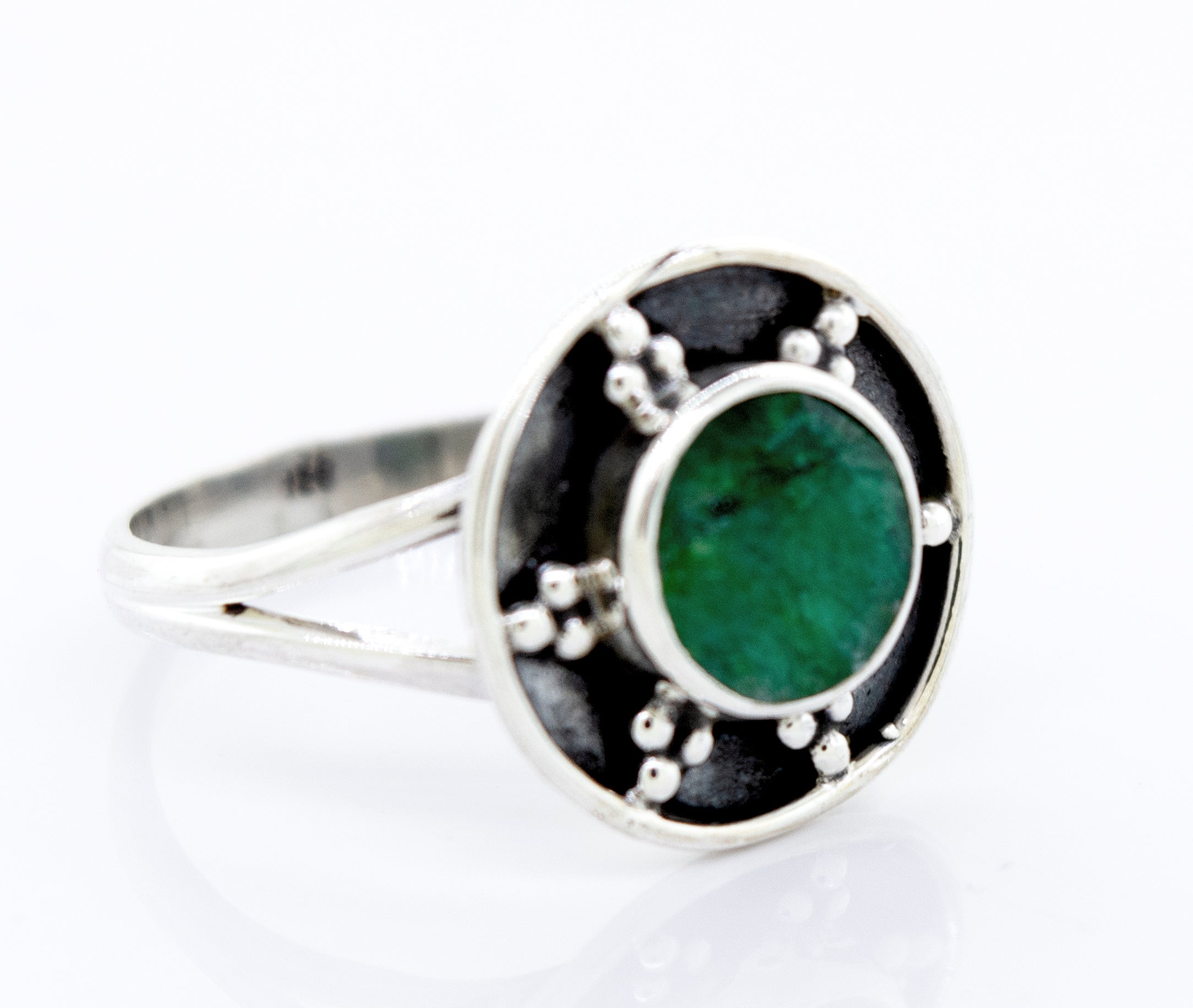 A Gemstone Ring With Unique Oxidized Design with a round green stone centerpiece, surrounded by small silver decorative elements on an oxidized silver circular background.