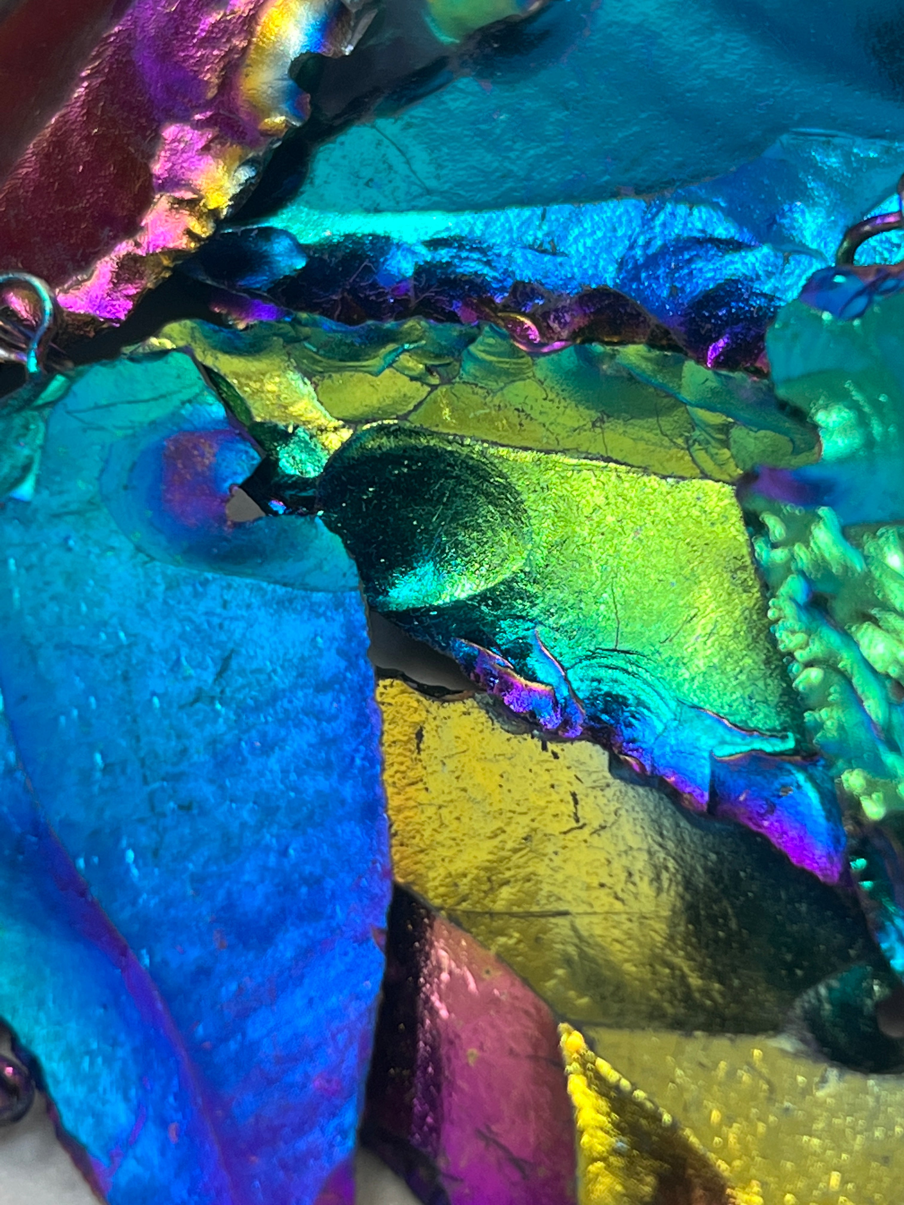 A close up of a Super Silver Rainbow Hematite Arrowhead Pendant adorned with a silver chain.