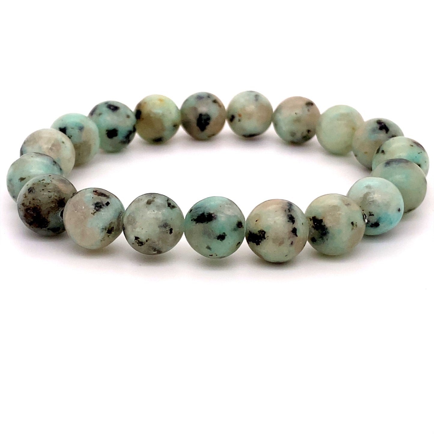 
                  
                    A 4mm Beaded Stone Bracelet made of kiwi jasper beads, recognized as a healing stone, with varying shades of pale green and black speckles, arranged in a circular shape on a white background.
                  
                