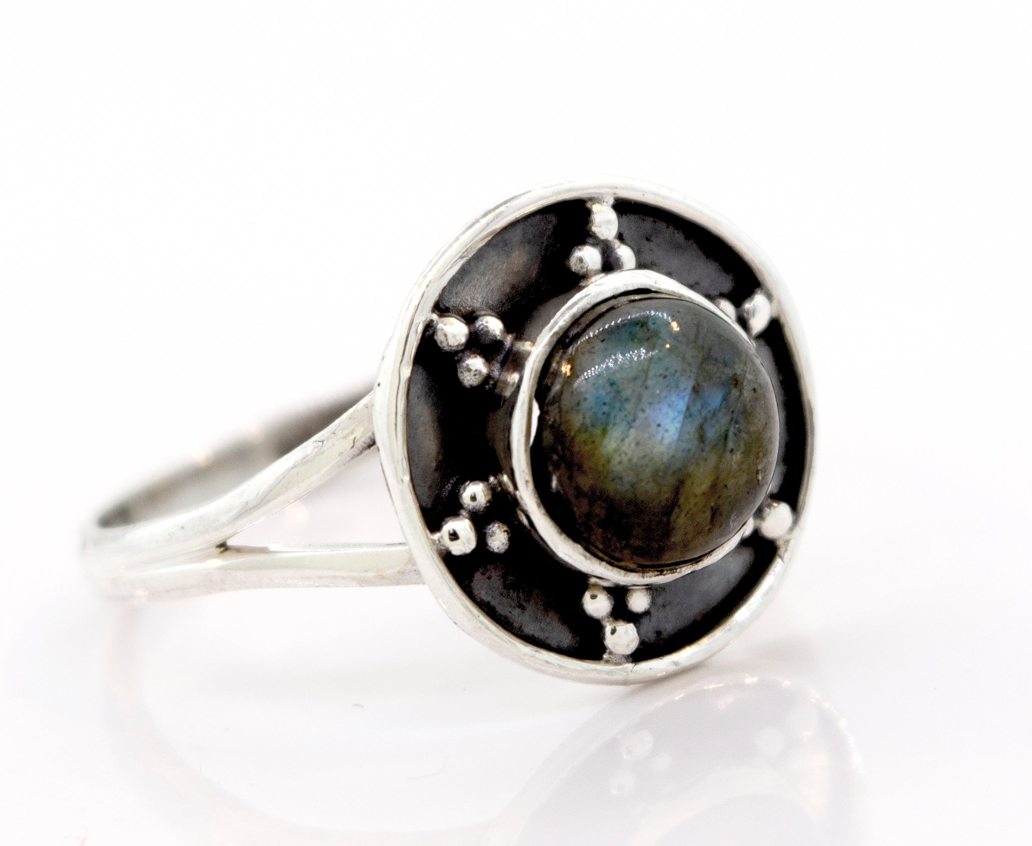 A Gemstone Ring With Unique Oxidized Design featuring a round, dark gemstone at its center, surrounded by an intricate oxidized silver design with small bead accents.