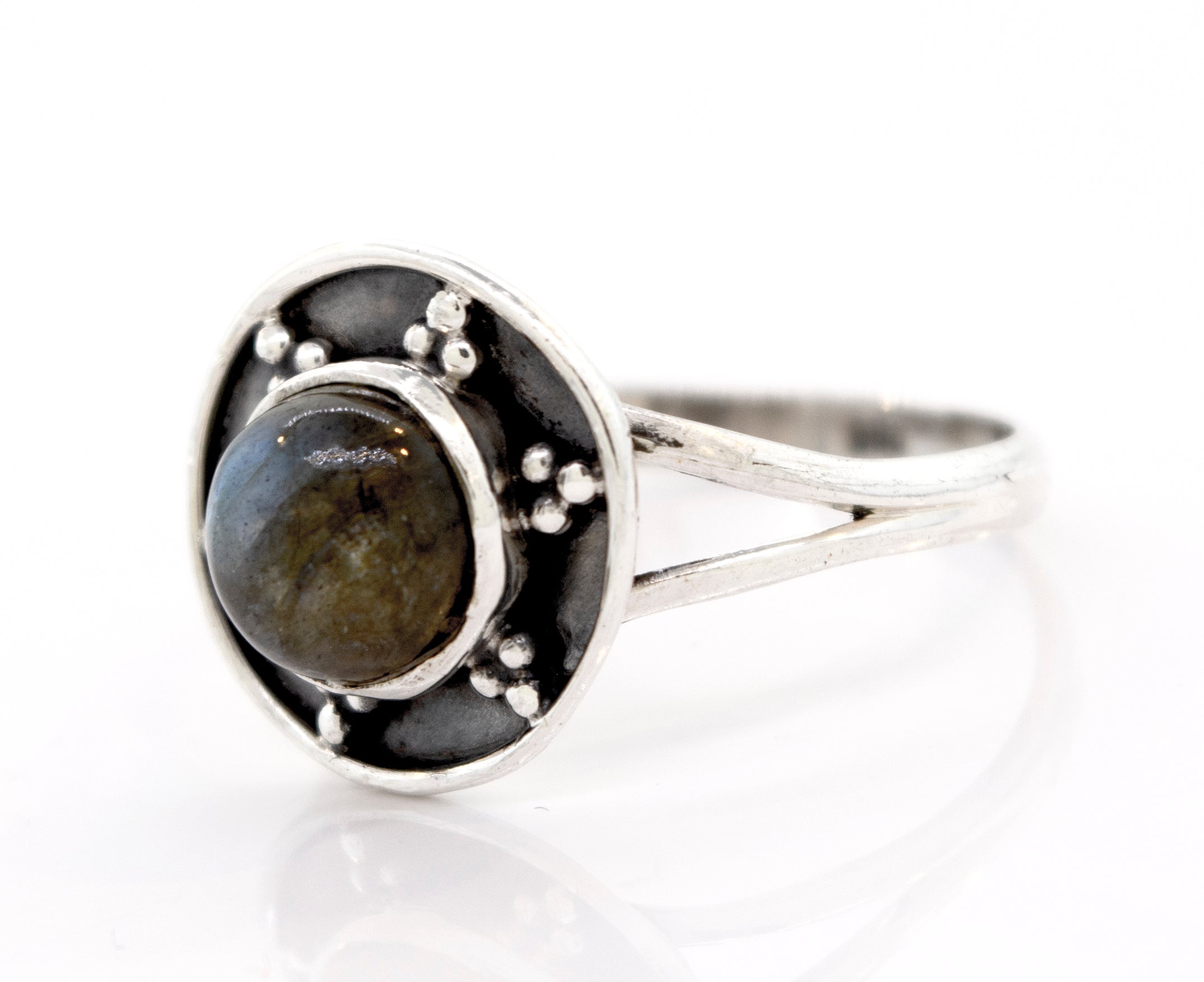 A Gemstone Ring With Unique Oxidized Design featuring a round, dark gemstone encased in a circular, decorative setting.