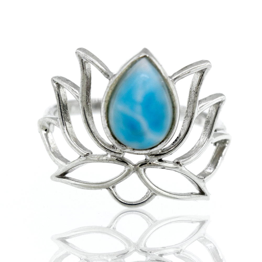 
                  
                    Online Exclusive Teardrop Stone Lotus Ring with a teardrop blue gemstone in the center, on a reflective white surface.
                  
                