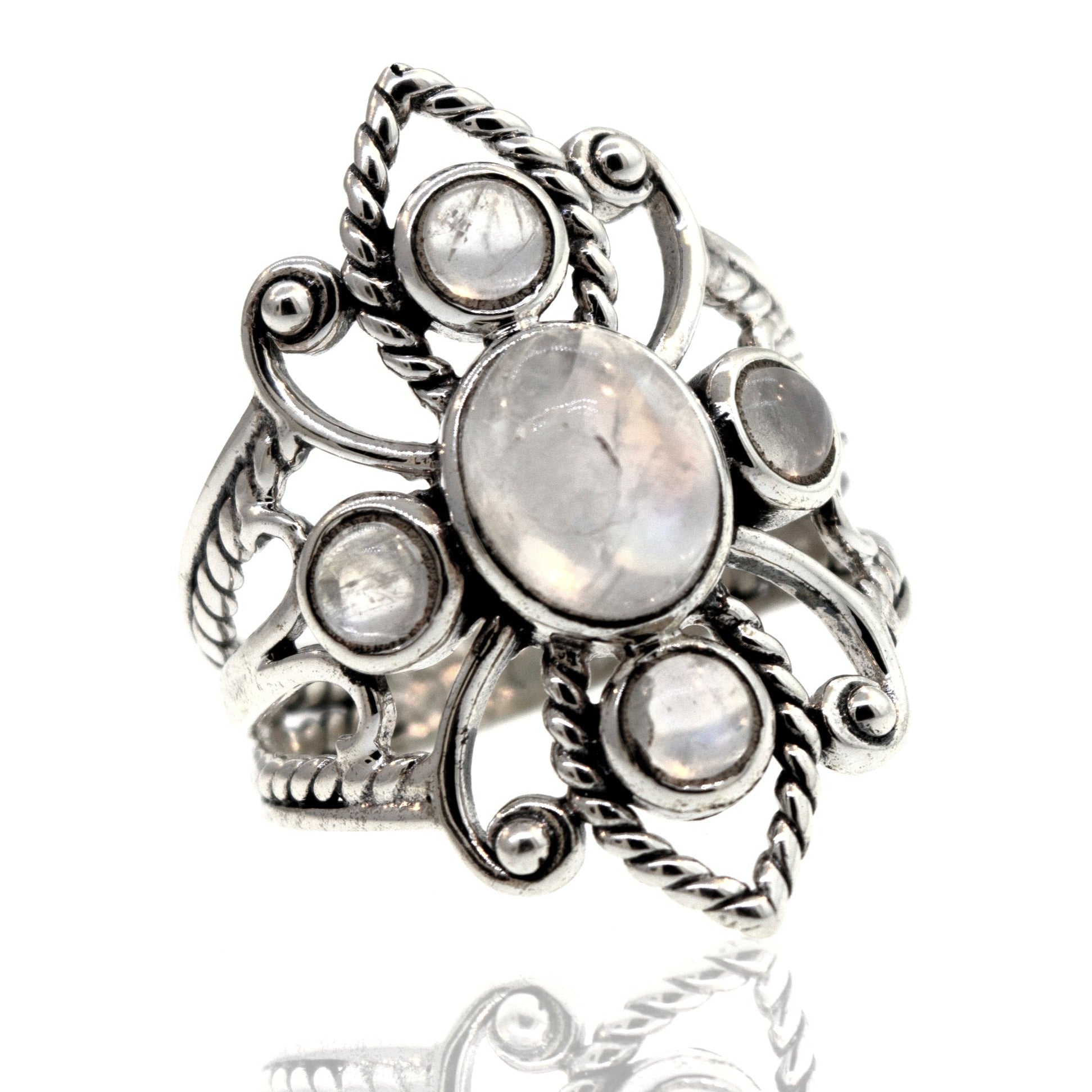 Online Only Exclusive Multistone Ring with a central moonstone and smaller surrounding carnelian stones, displayed against a white background with a reflection below.