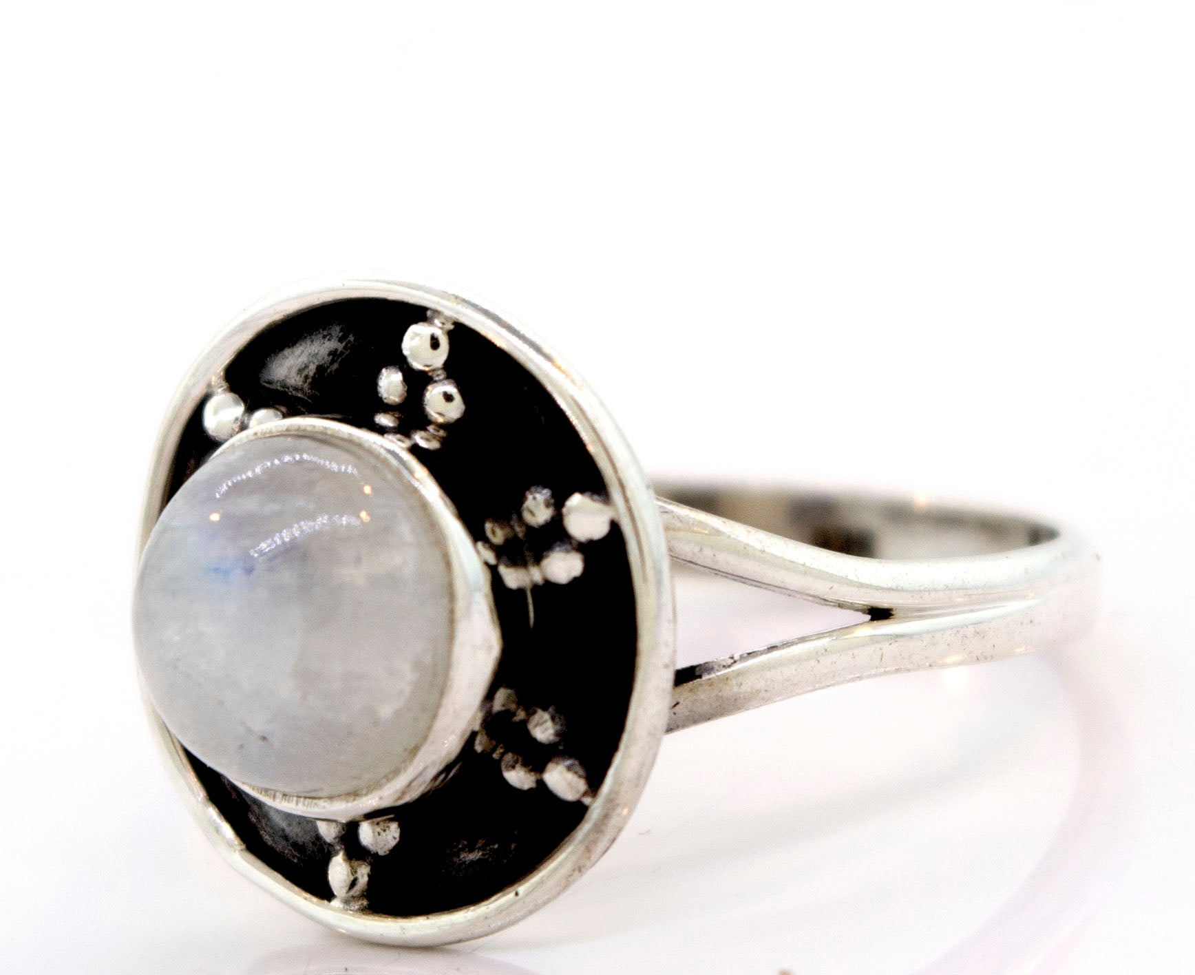 A Gemstone Ring With Unique Oxidized Design featuring a round, polished gemstone at its center, surrounded by a circular black-and-silver oxidized silver setting with small decorative metal dots.