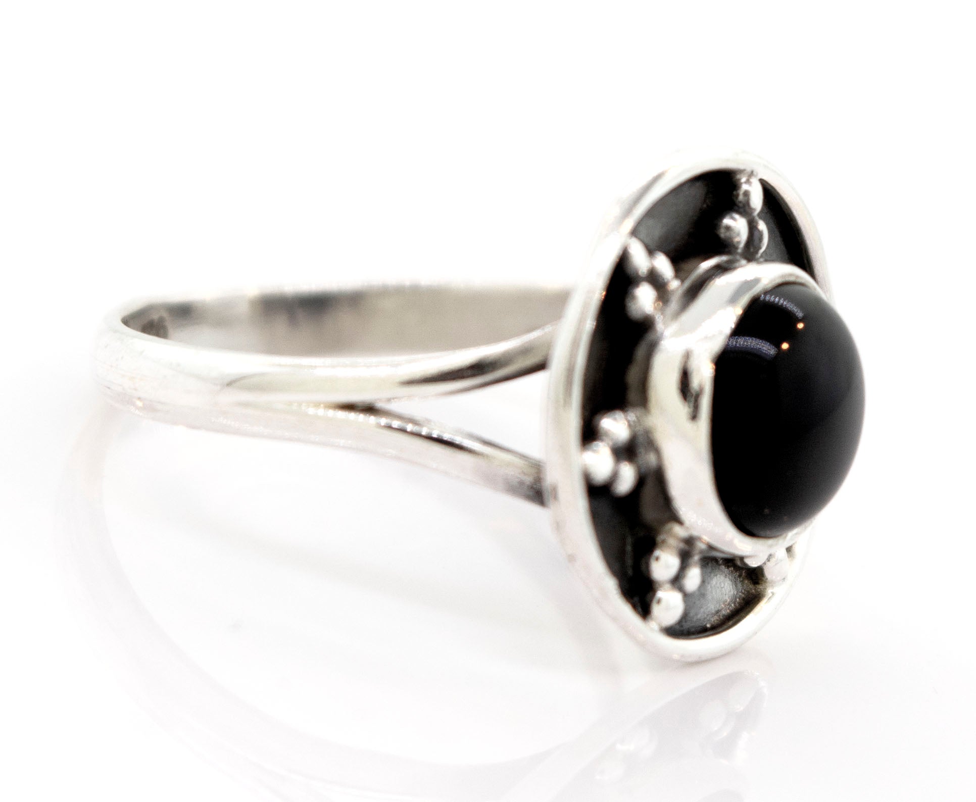 A Gemstone Ring With Unique Oxidized Design with a round black stone at its center, featuring a raised circular setting with small decorative elements around the stone.