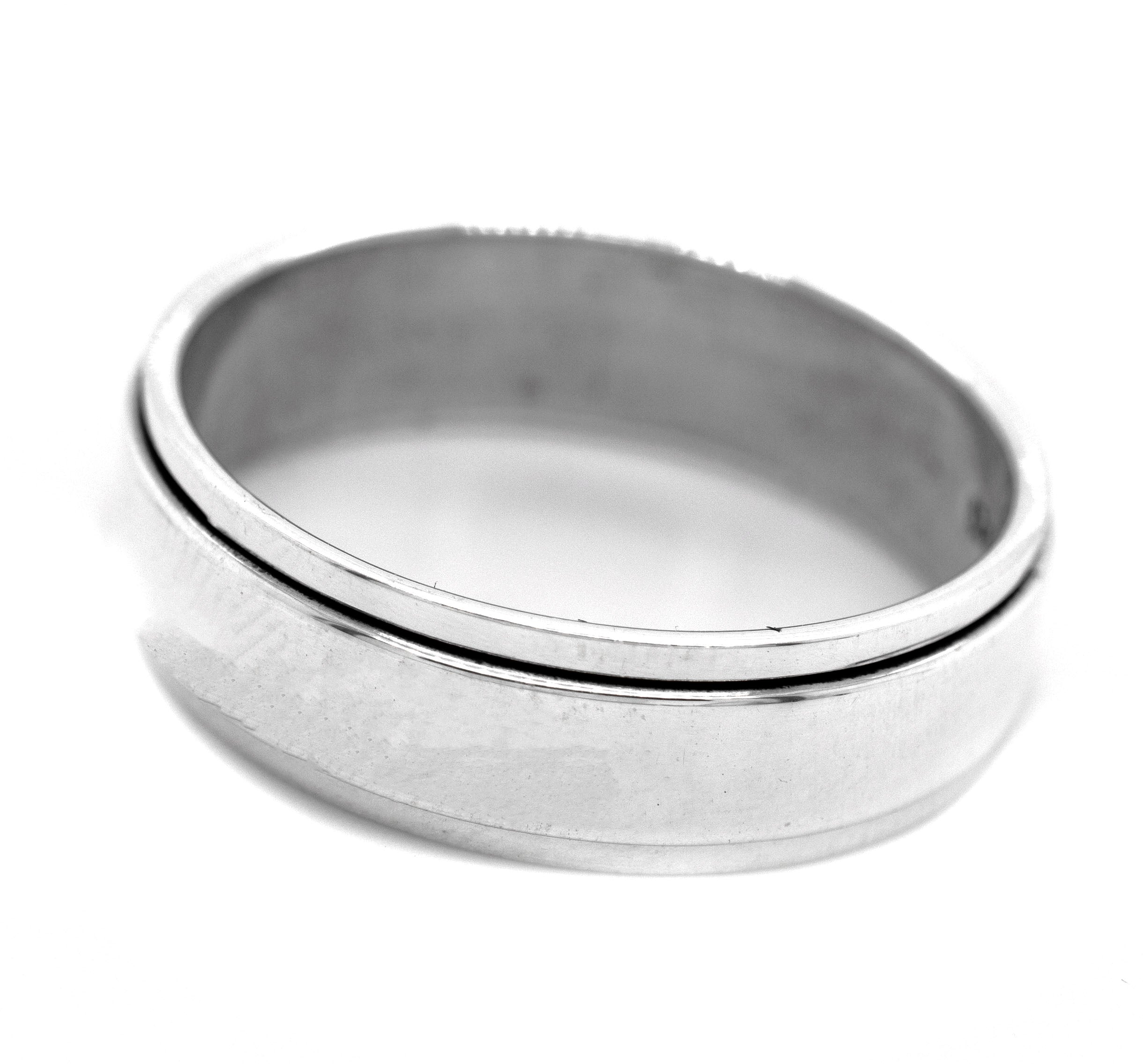 The Simple Silver Spinner Rings feature a subtle diagonal groove detail in plain sterling silver—photographed on a white background, they are minimalist fidget rings perfect for soothing nerves stylishly.