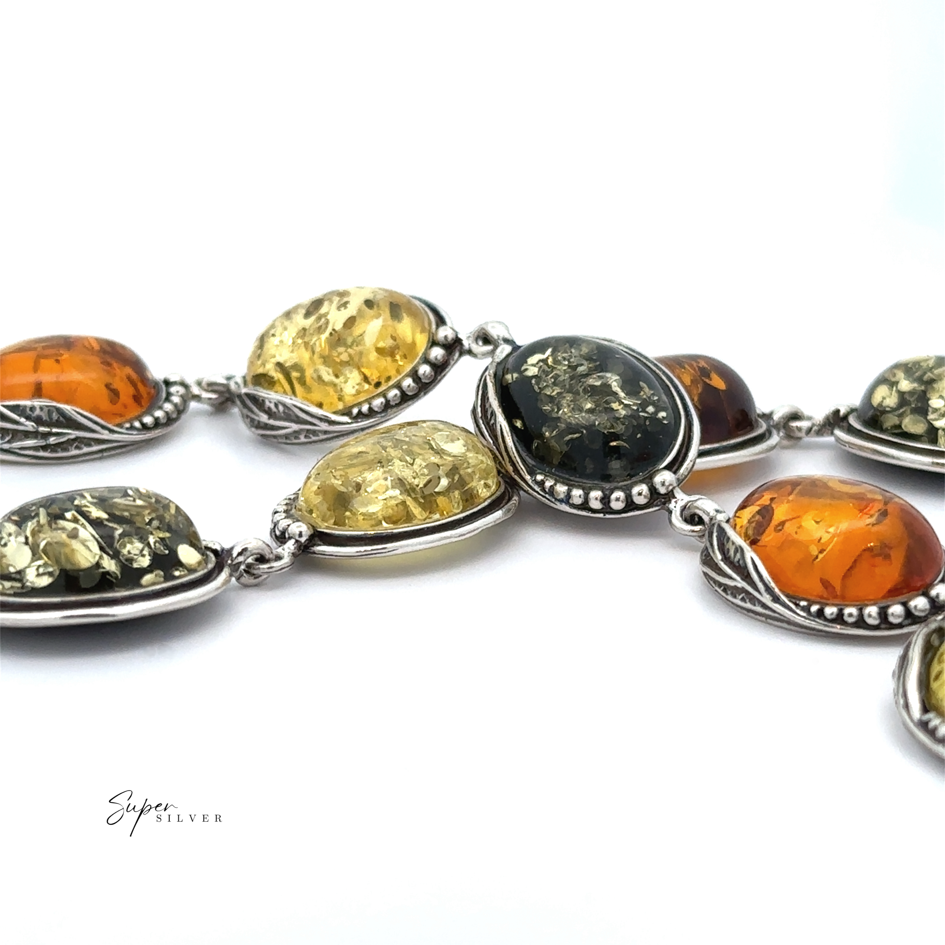 A detailed view of the Oval Amber Link Bracelet With Leaf Detail, showcasing its vintage charm with silver accents and adorned with oval Baltic amber stones in diverse hues of yellow and orange.