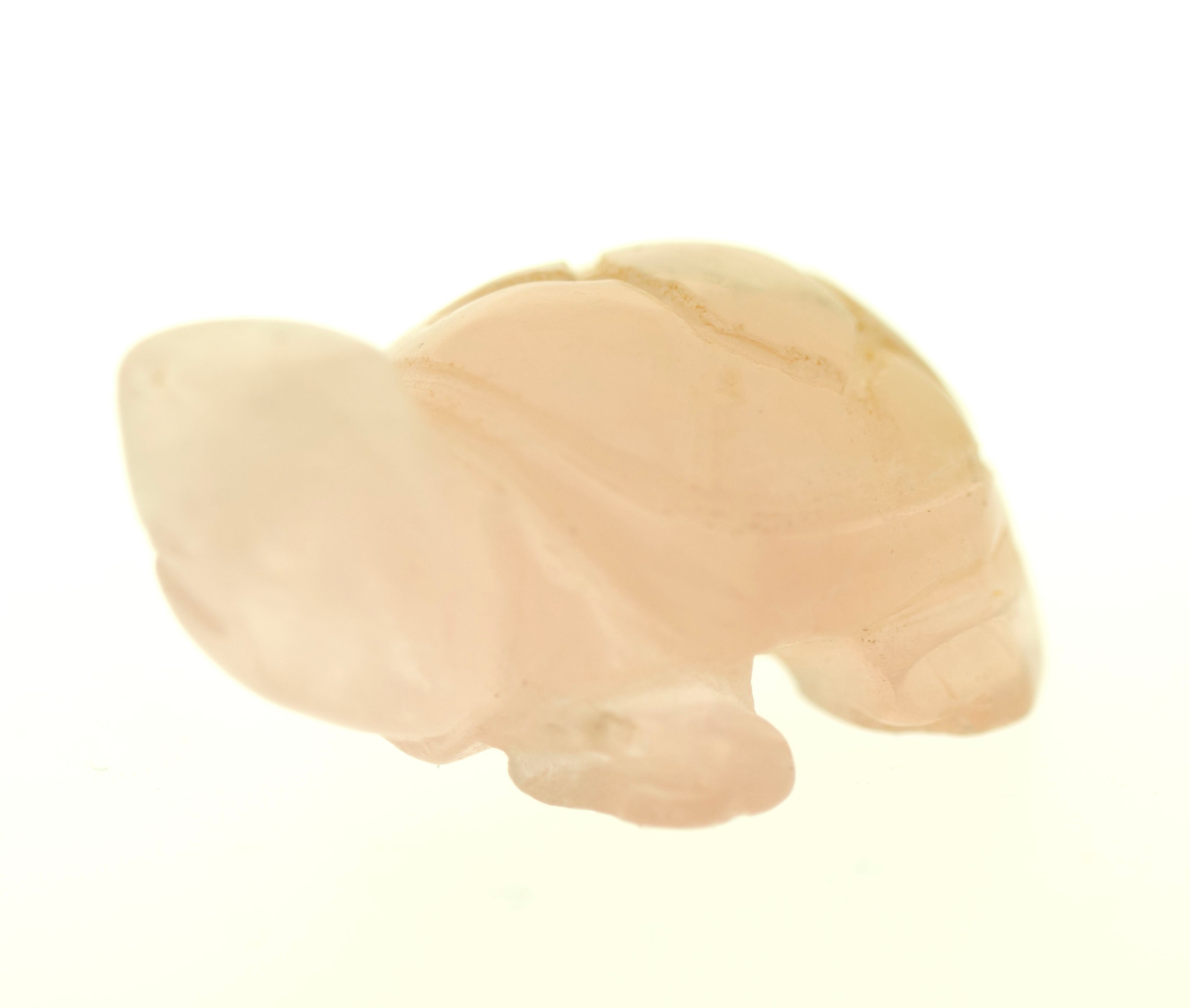 A small, light pink Carved Turtle Gemstone Figures made of Rose Quartz against a white background.