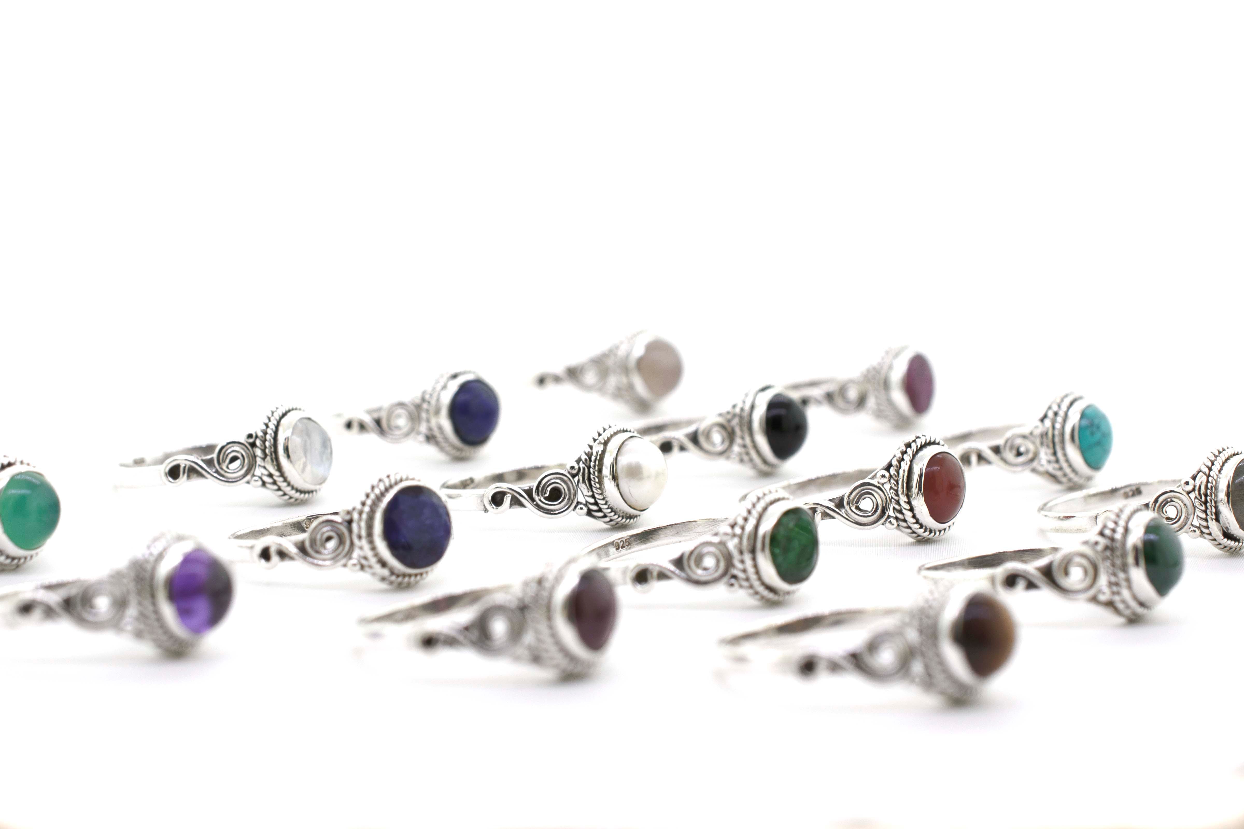 A collection of Gemstone Circle Rings With Rope Border And Swirl Design featuring an array of colorful stone cabochons.
