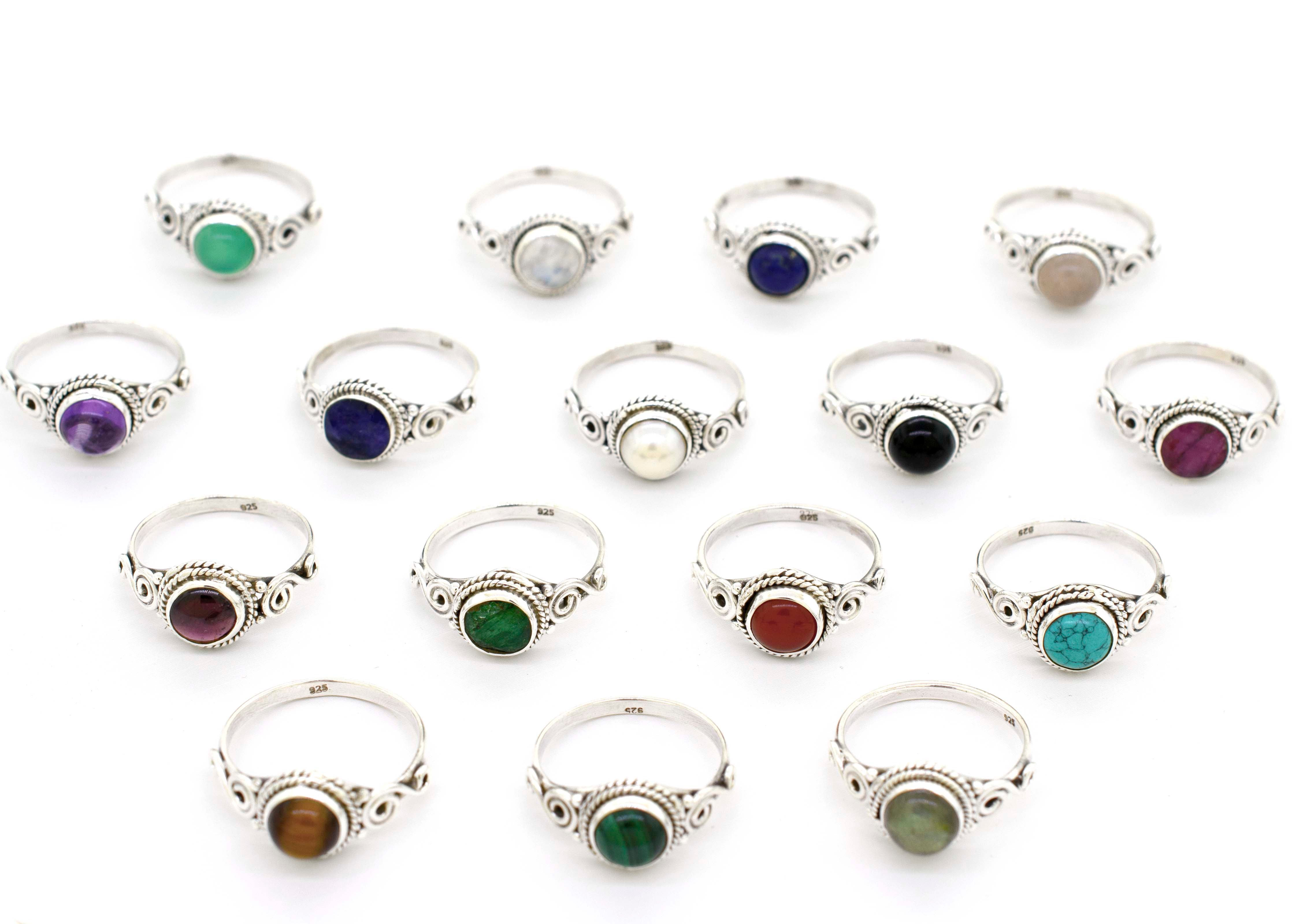 A group of Gemstone Circle Rings With Rope Border And Swirl Design adorned with different colored stones.