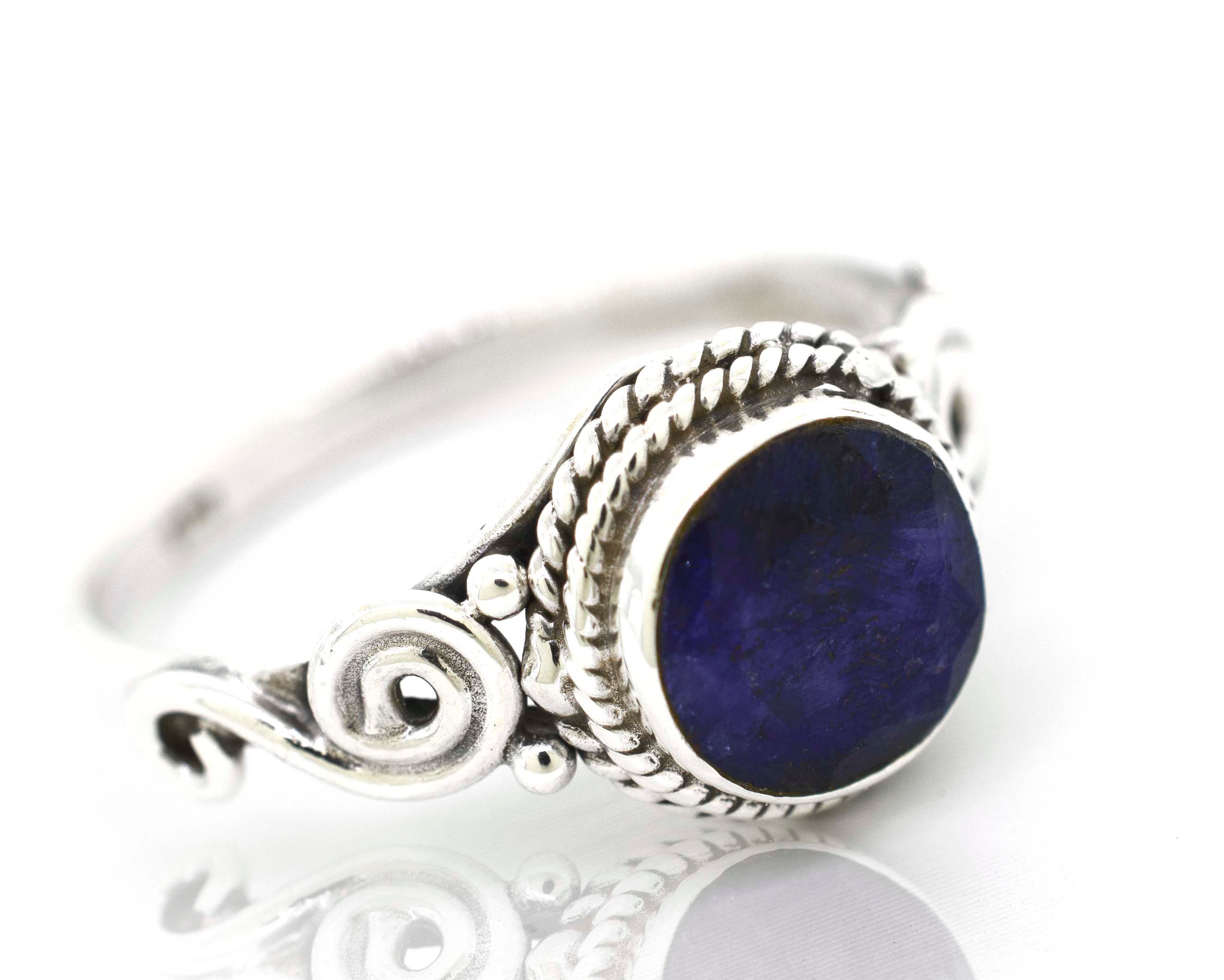 A Gemstone Circle Ring With Rope Border And Swirl Design with a lapis stone in a cabochon setting.