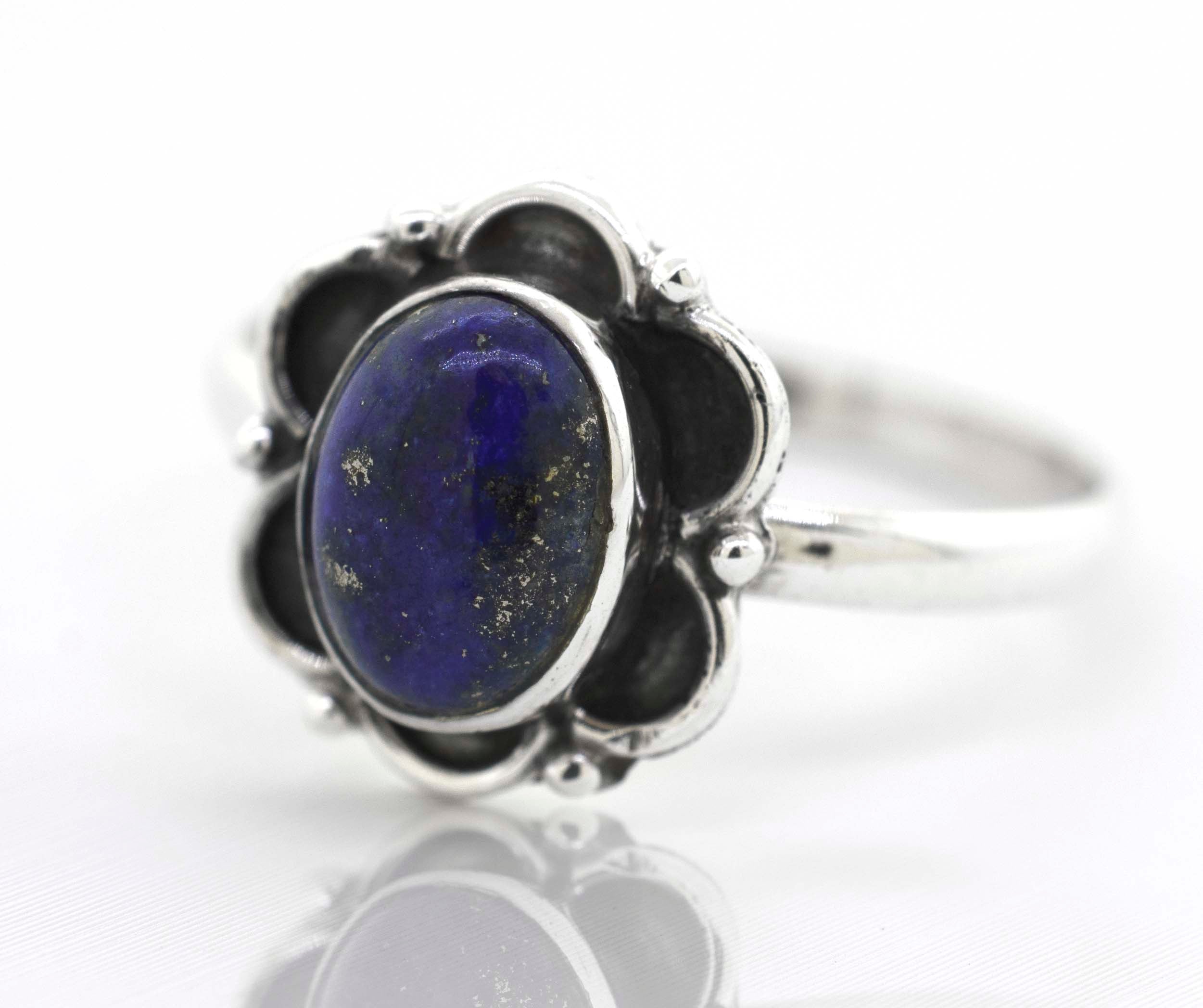 A Gemstone Ring With Oxidized Flower Design with a lapis cabochon stone in the center.