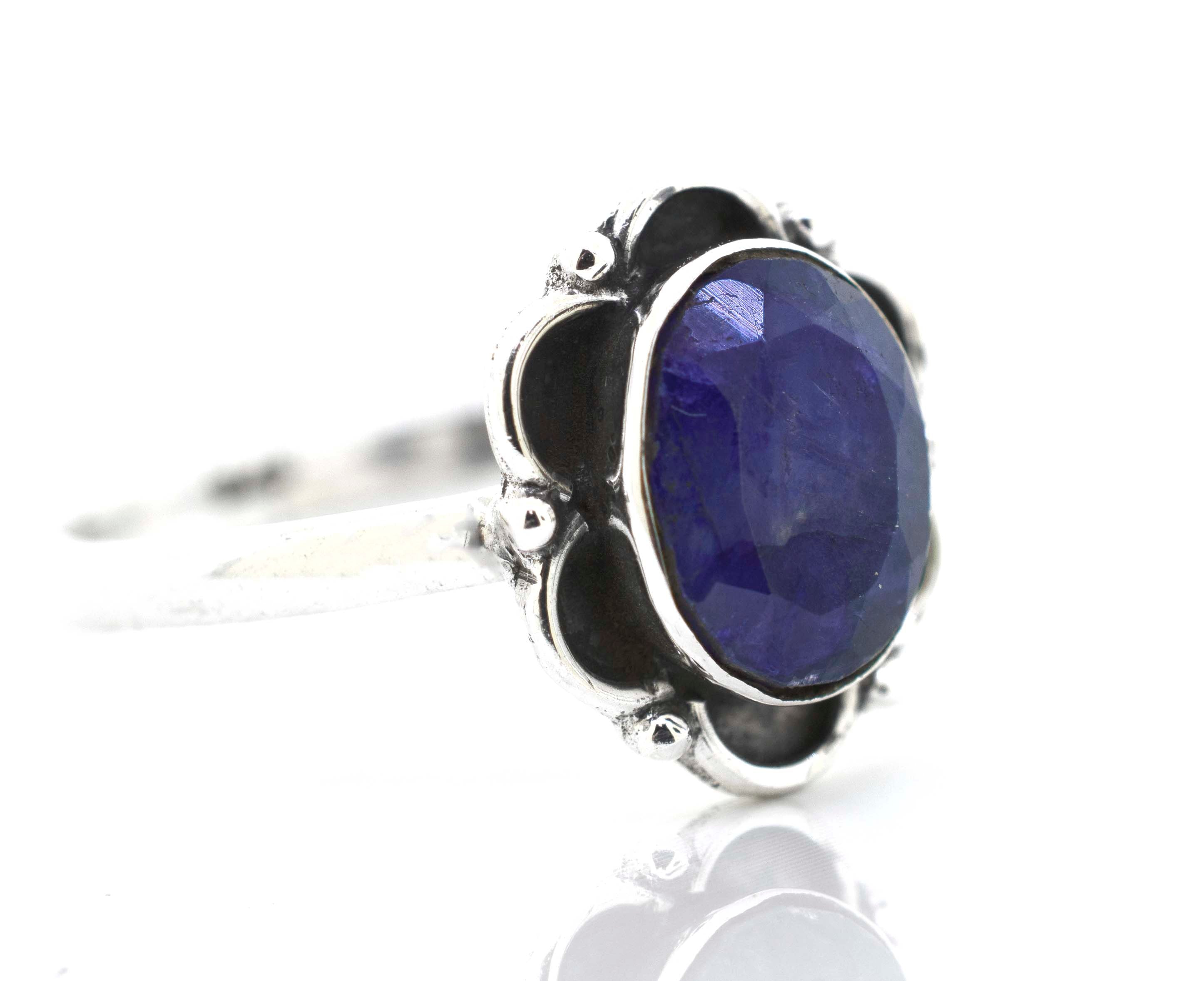 A delicate Gemstone Ring With Oxidized Flower Design by Super Silver with a central blue sapphire stone.