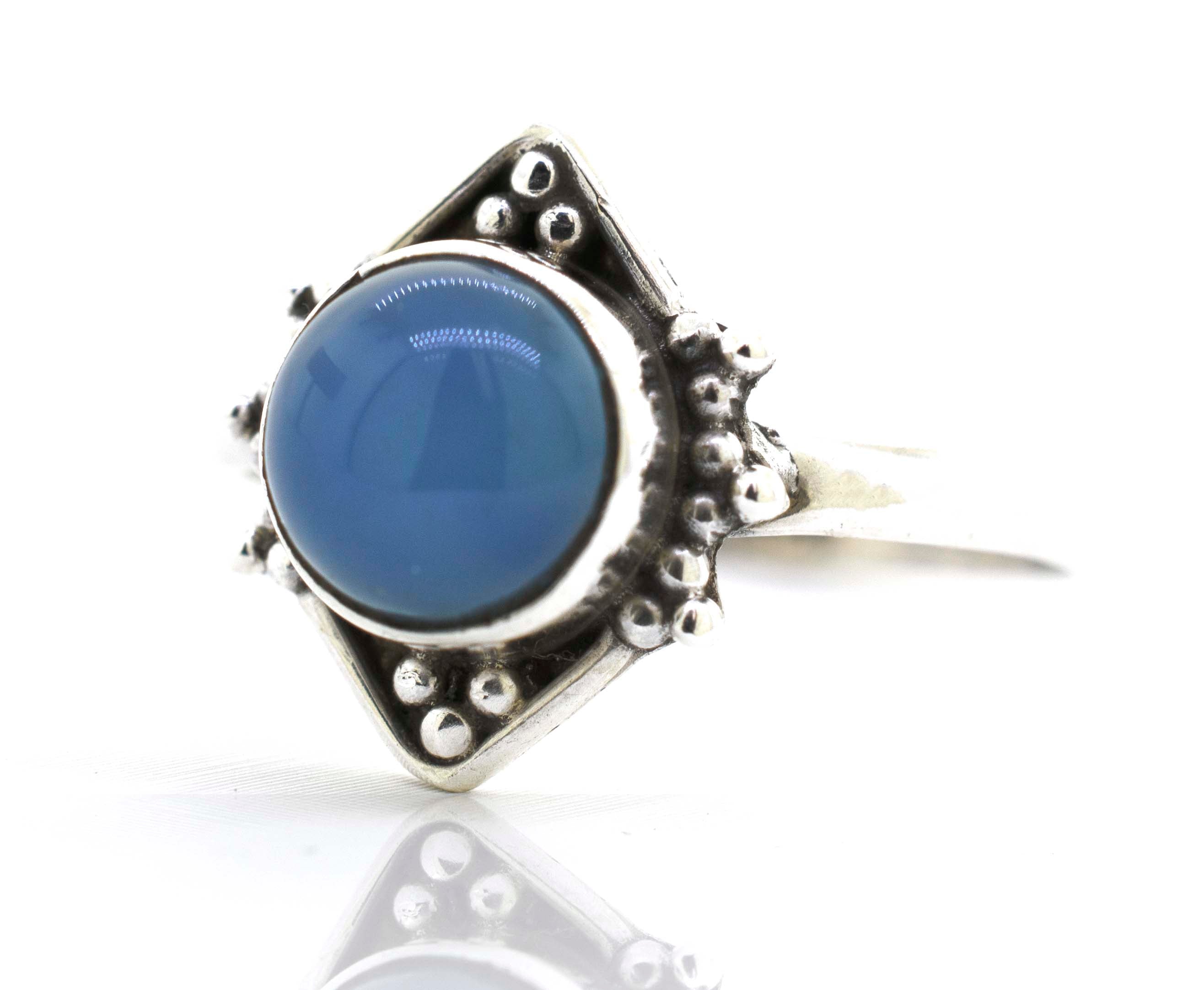 A round gemstone ring with oxidized diamond shape pattern.