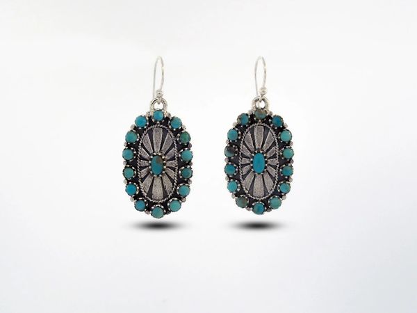 These Super Silver Western Inspired Oval Turquoise Earrings With Sunburst Design feature a sunburst design.