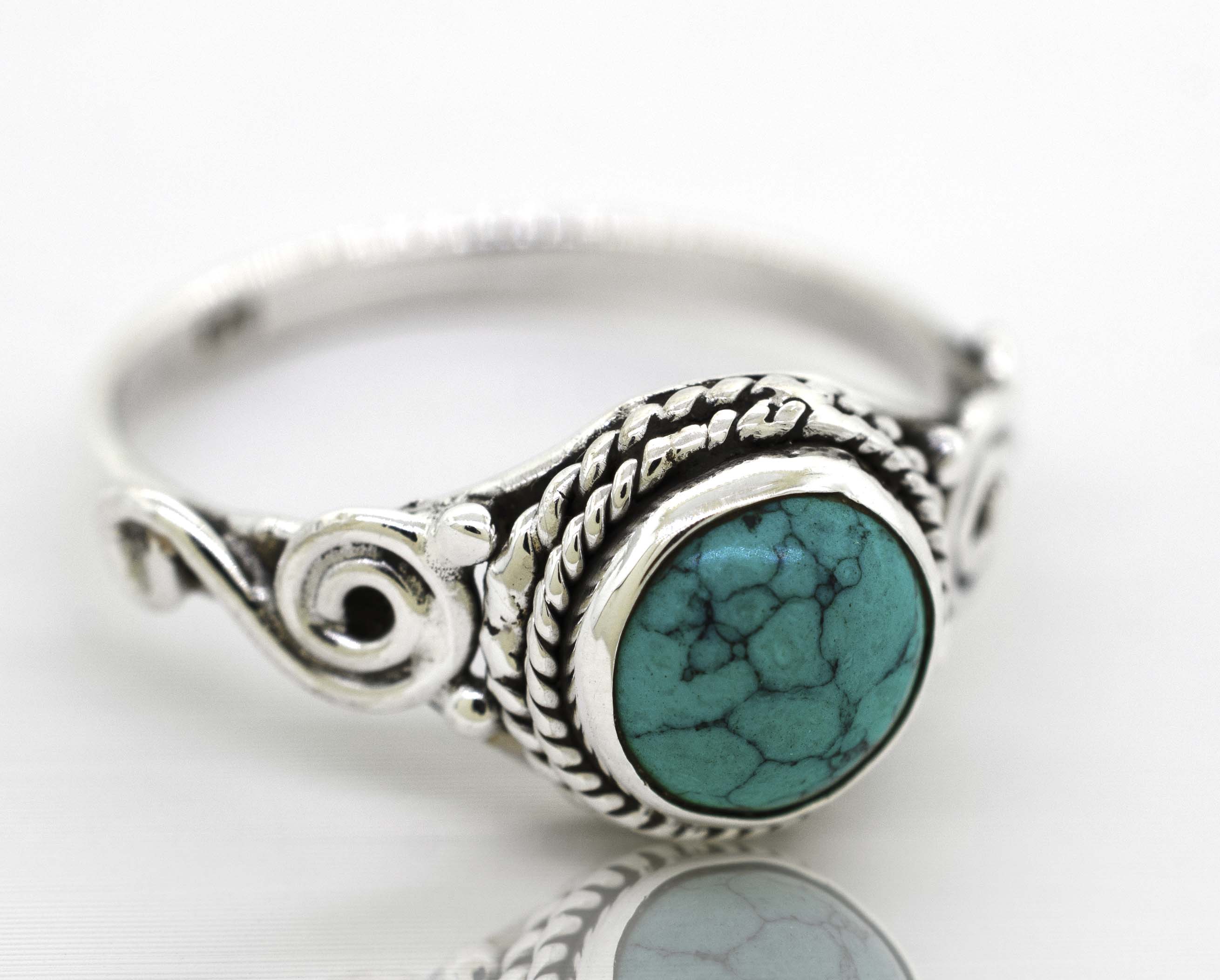 A Super Silver Gemstone Circle Ring With Rope Border And Swirl Design with a bohemian vibe and a turquoise gemstone.