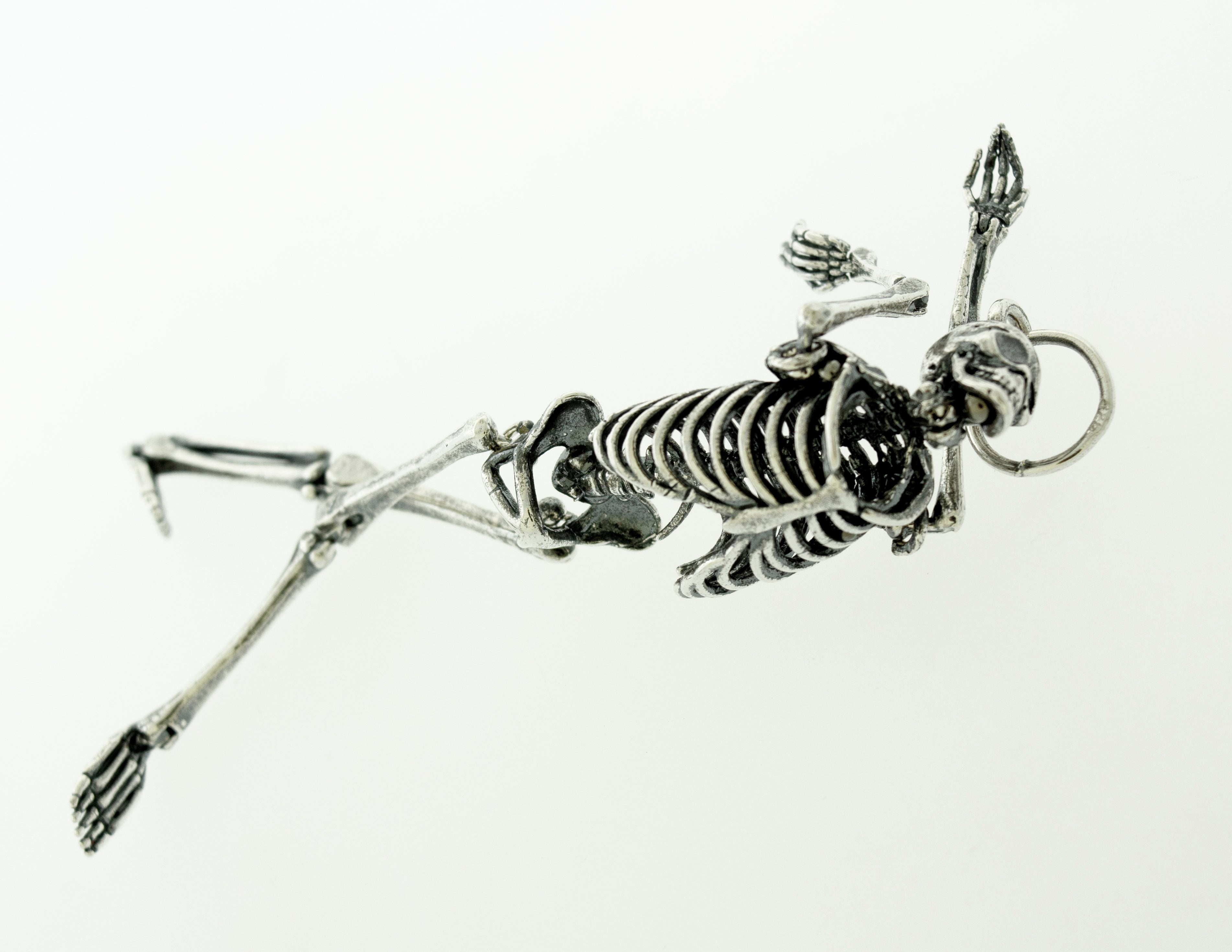 A statement piece, a Super Silver Large Skeleton Pendant, laying on a white surface.