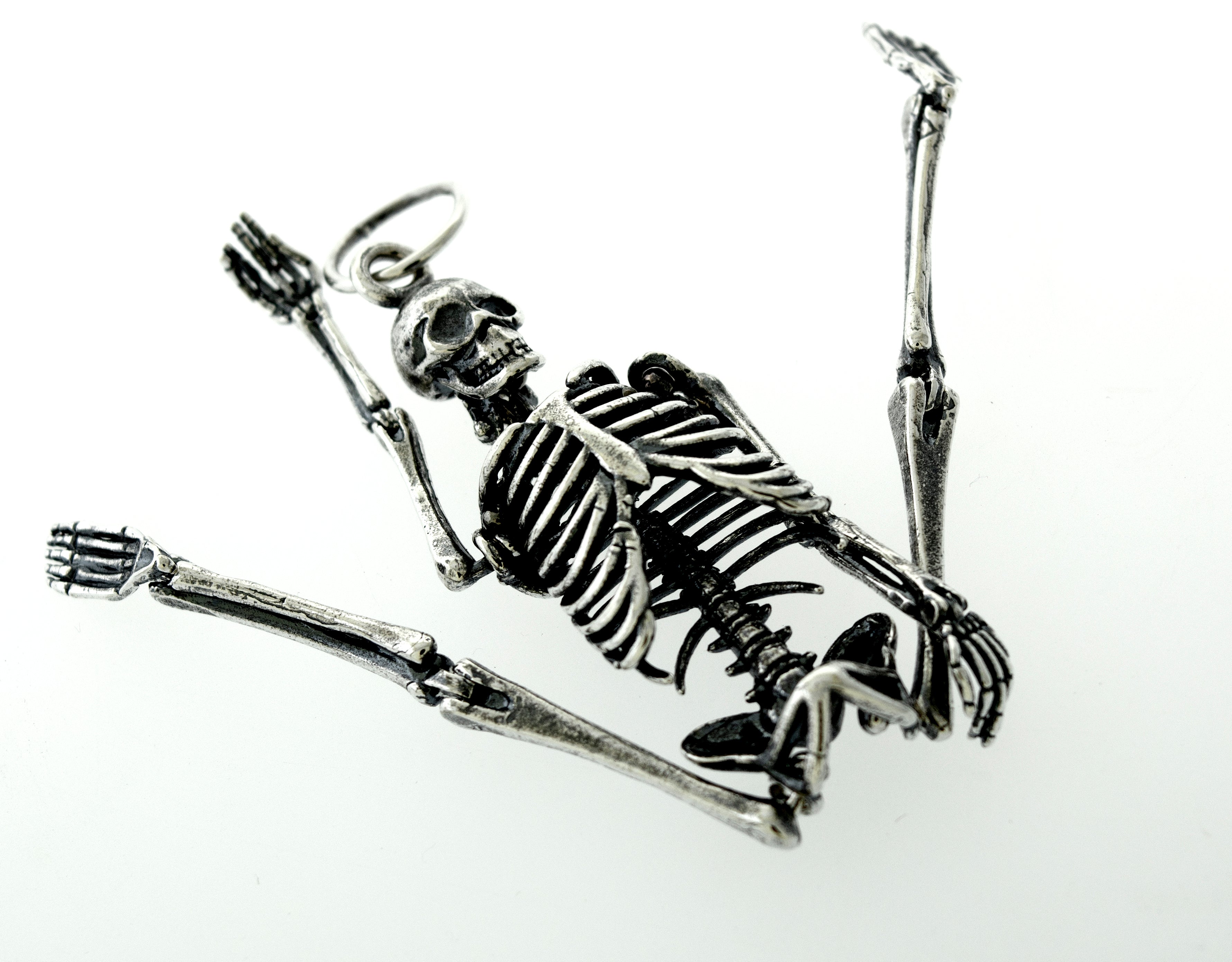 A statement piece adorned with a Super Silver Large Skeleton Pendant, elegantly resting on a white surface.
