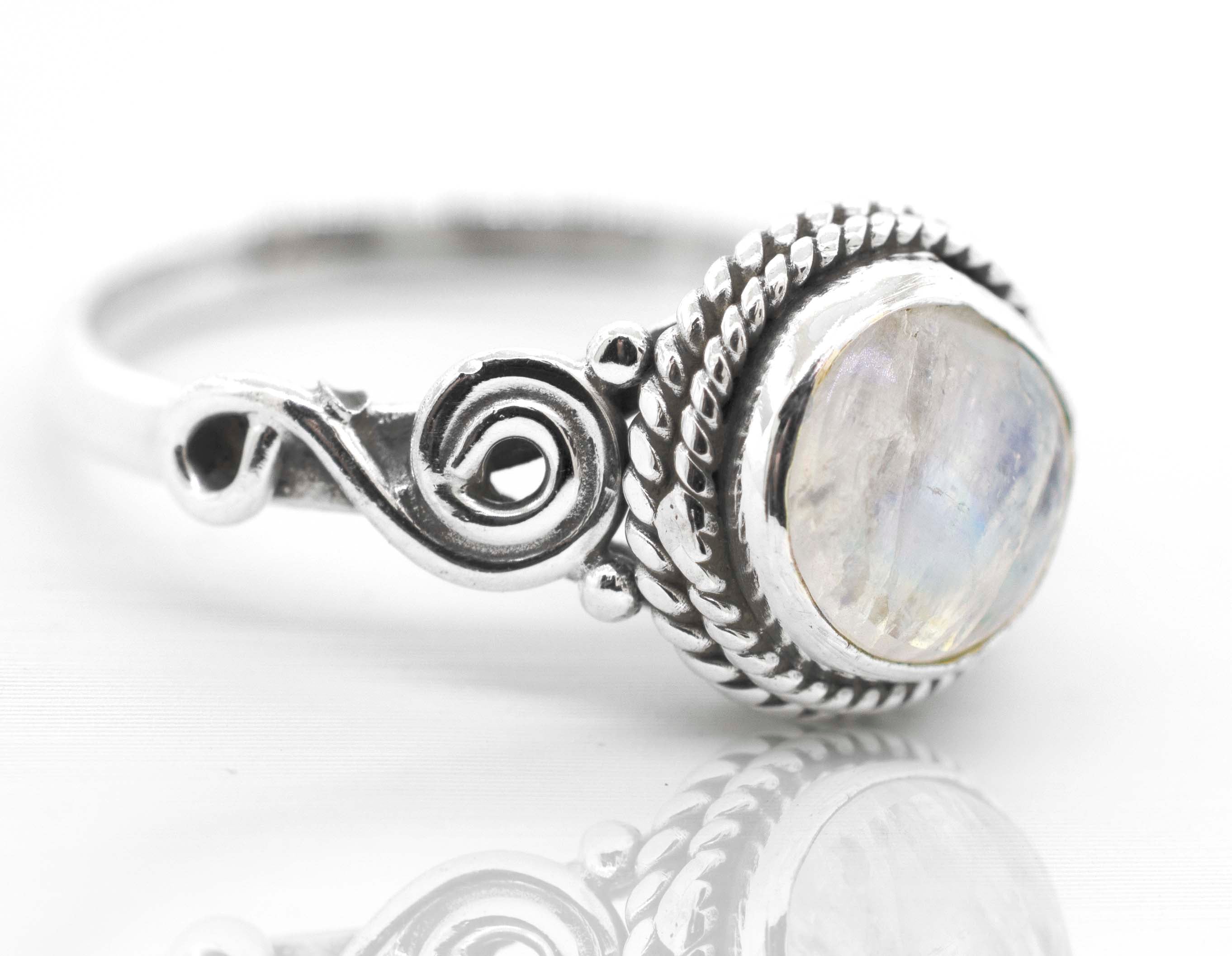 A bohemian vibe Super Silver Gemstone Circle Ring With Rope Border And Swirl Design with a moonstone in the center.