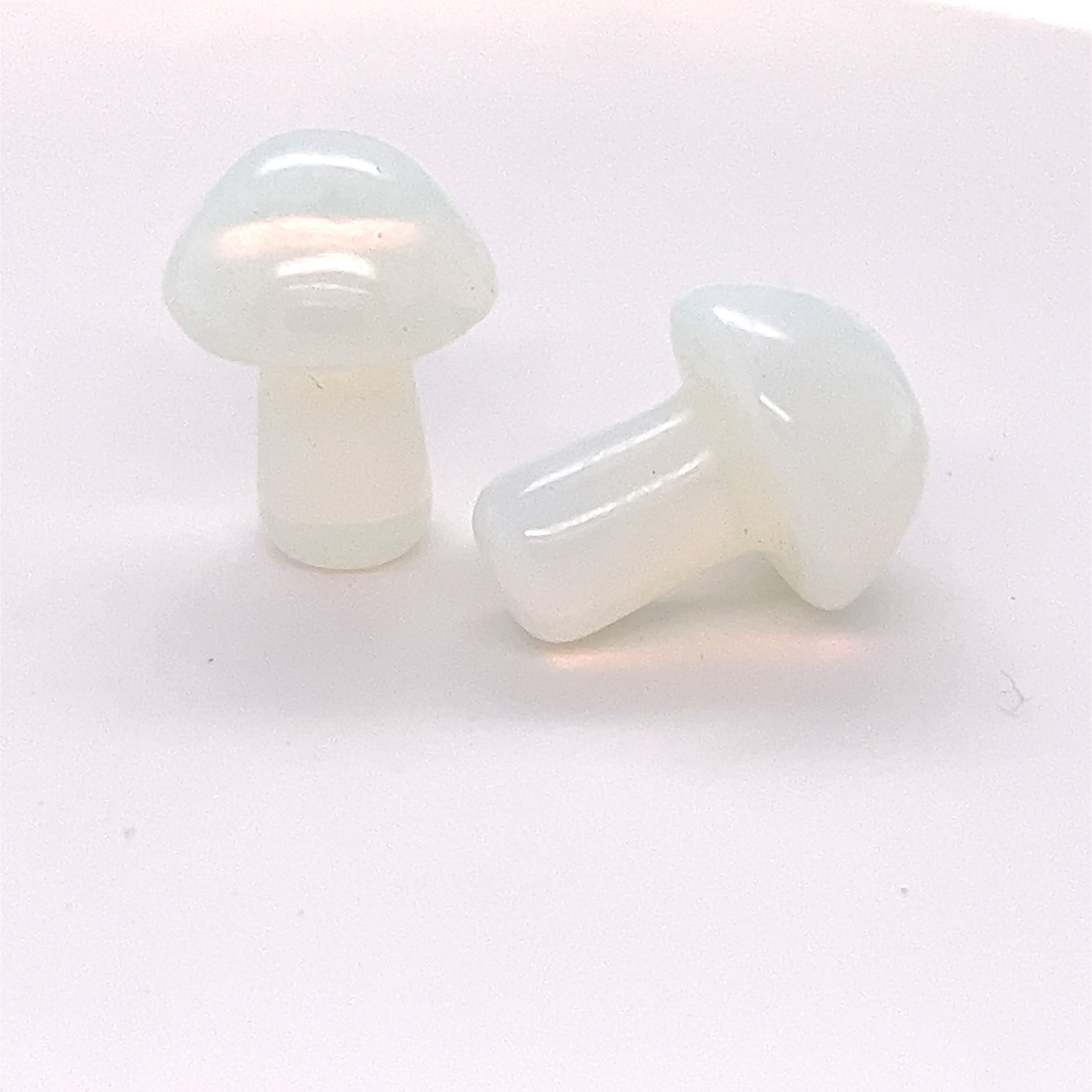Two Super Silver Opalite Stone Mushroom plugs on a white surface.