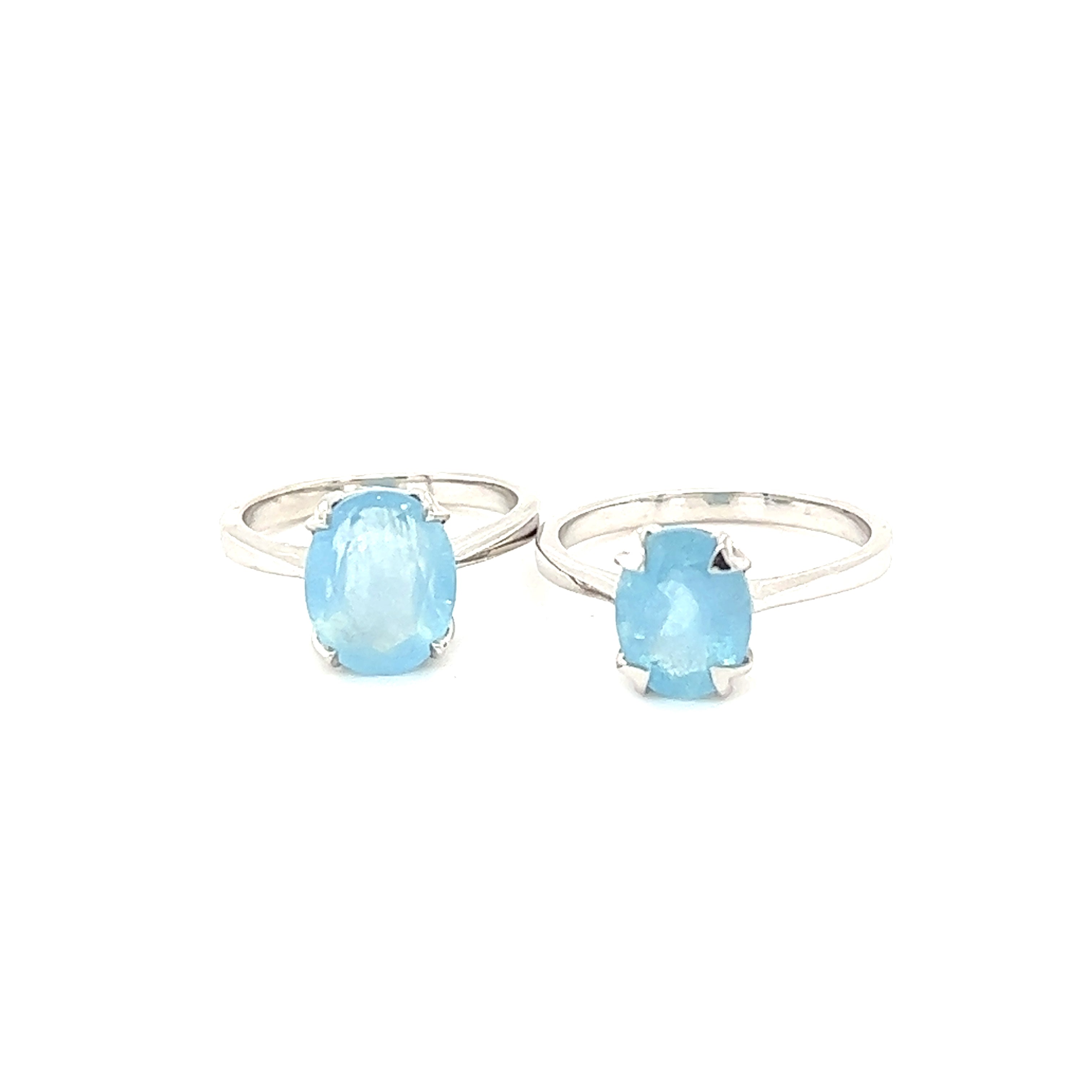 Two Super Silver Aquamarine Rings with blue topaz gemstones on a white background.