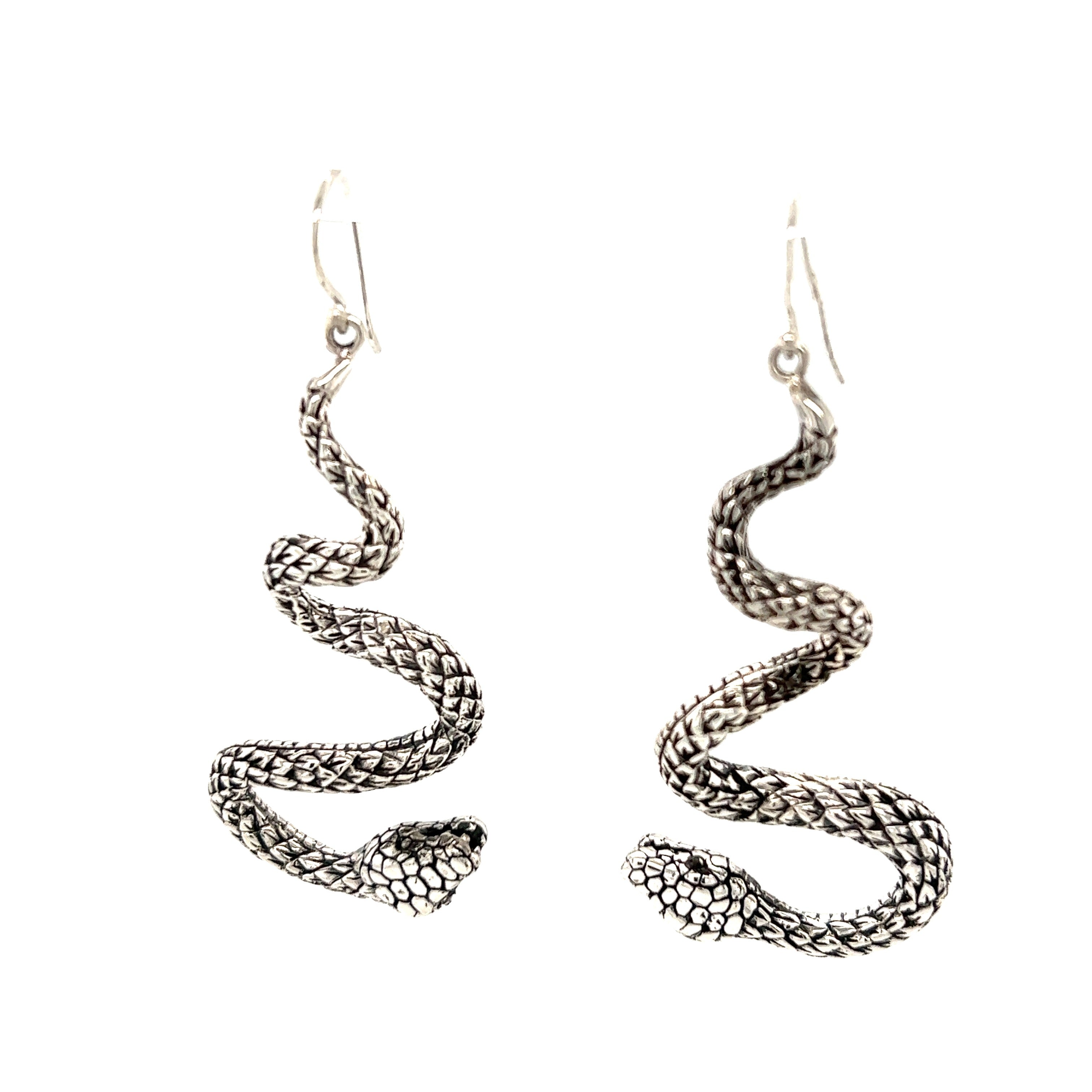 Handcrafted Super Silver long twisting snake earrings on a white background.