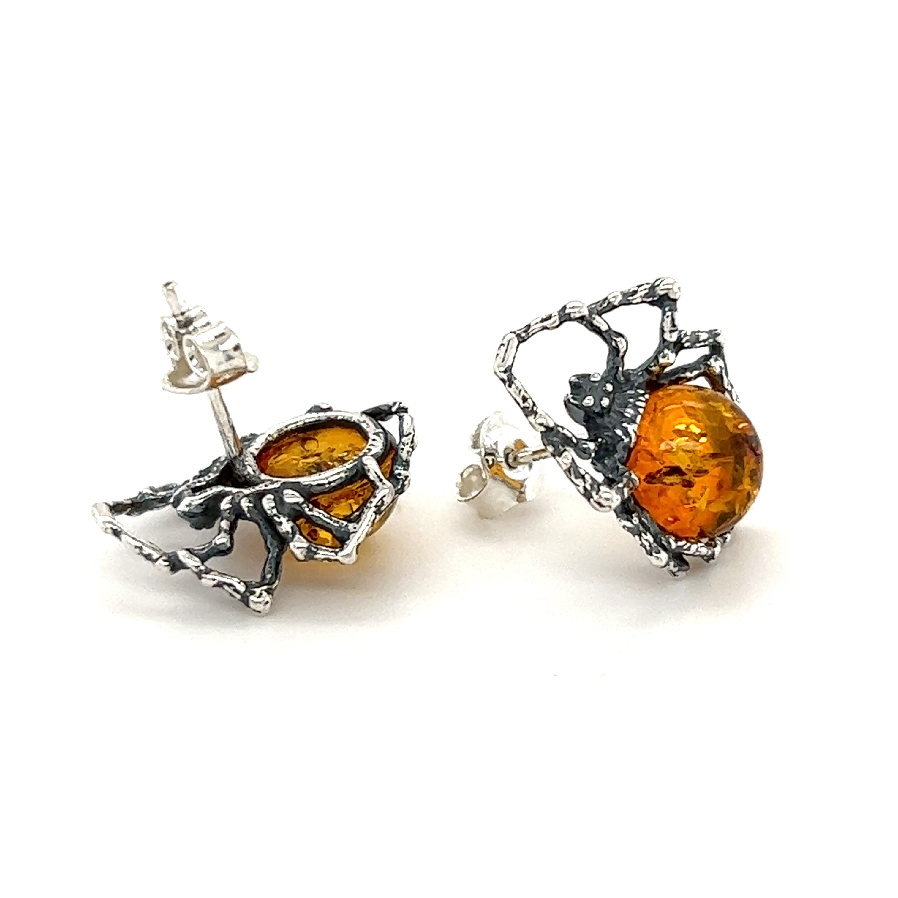 A pair of Super Silver Eerie Amber Spider stud earrings on a white background.