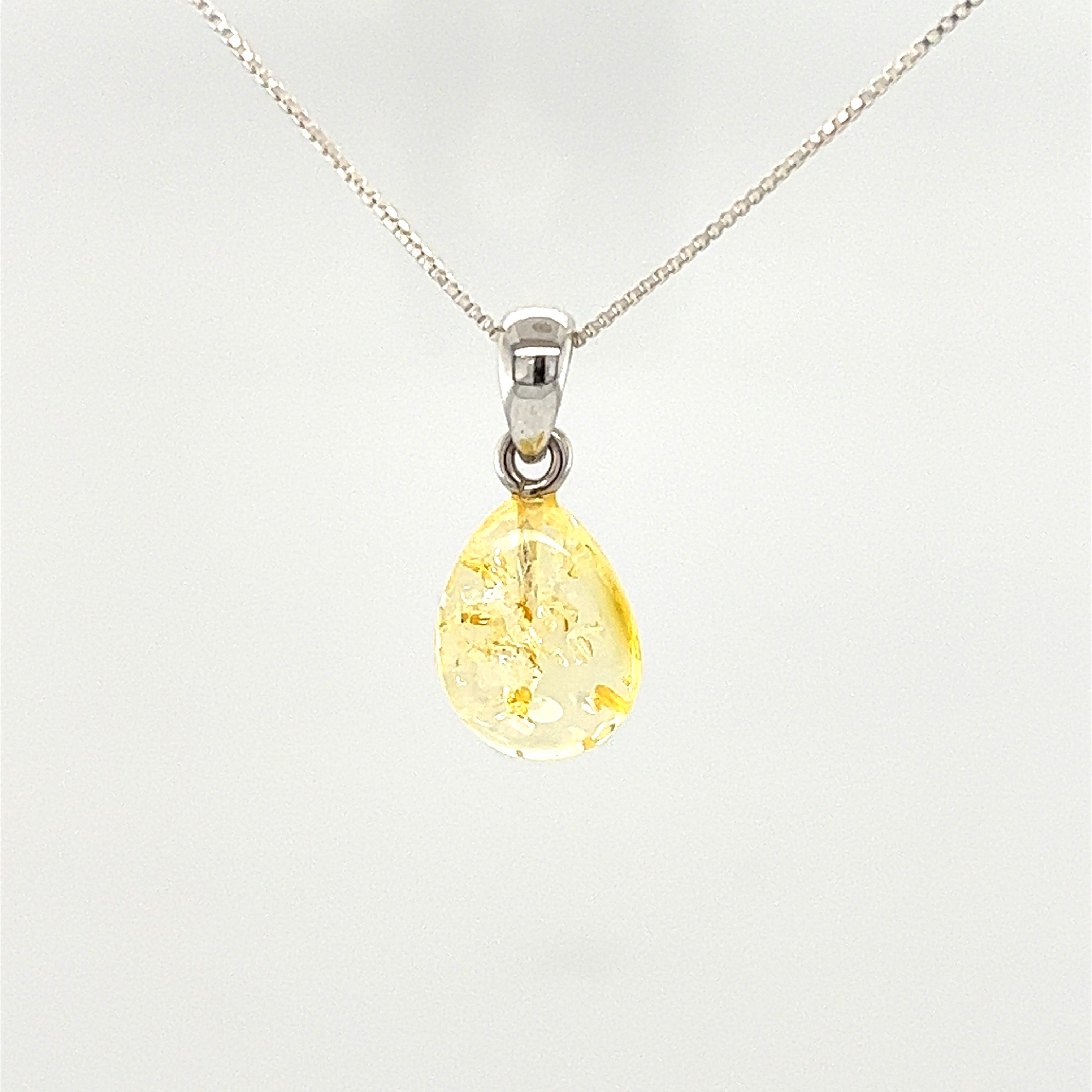 A Teardrop Amber Pendant made of Baltic amber, featuring a tear-shaped yellow stone, elegantly hanging on a Super Silver chain.