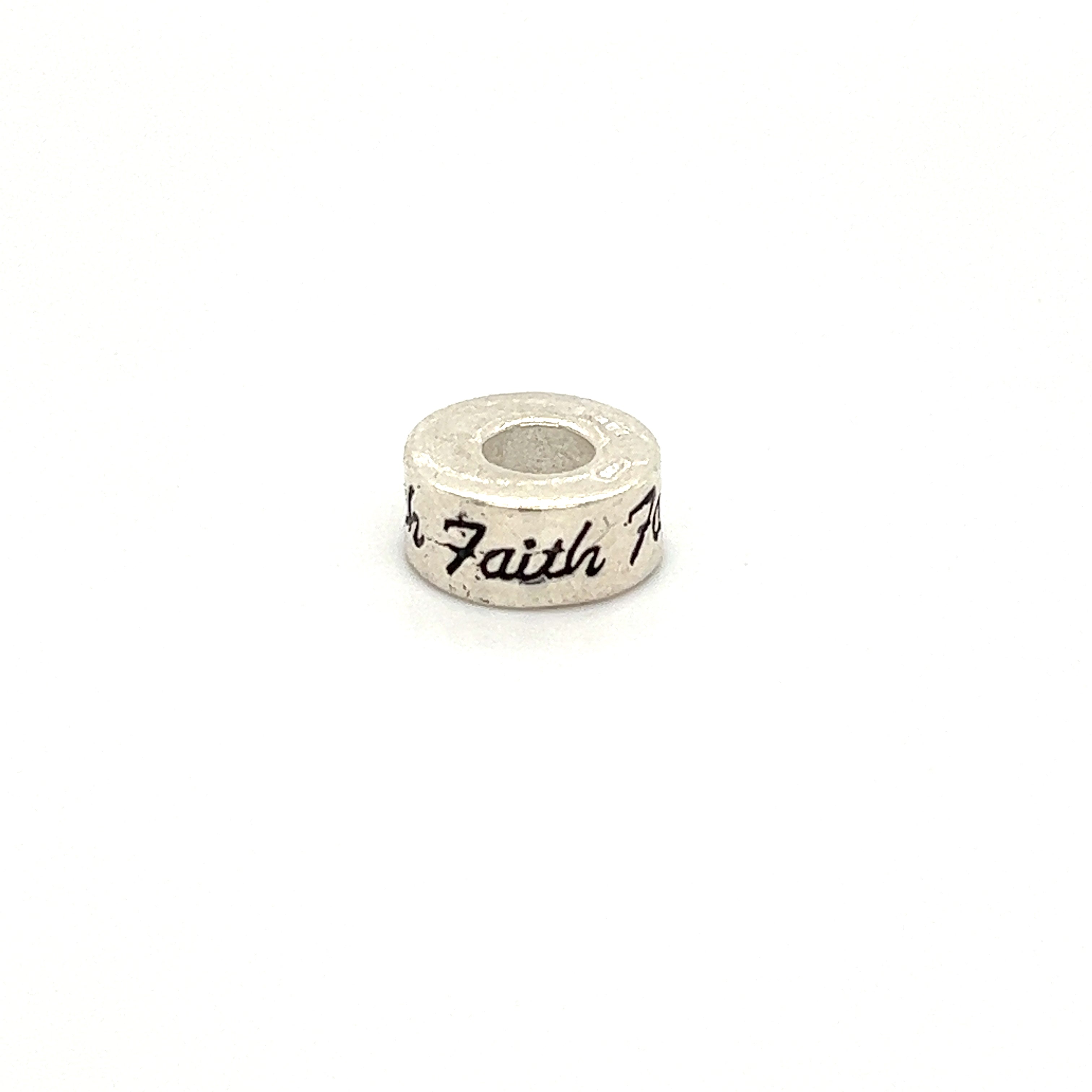 A Super Silver Affirmation Bead Charm with the word "faith" engraved on it.