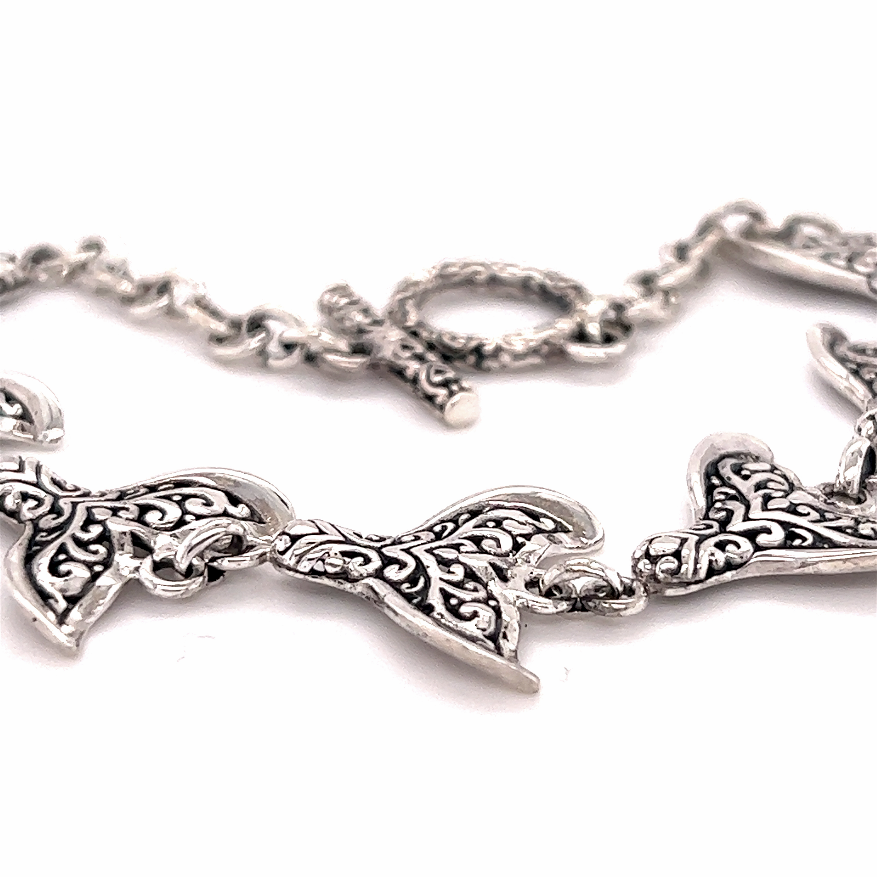 An ocean-themed Stunning Whale Tail Bracelet with ornate designs on it by Super Silver.