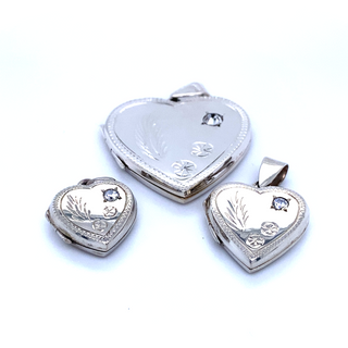 Three Super Silver heart shaped lockets with a romantic charm on a white surface.