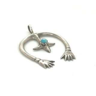 A Super Silver Native American Naja Pendant With Turquoise adorned with a captivating turquoise stone.