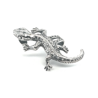 A resilient silver gecko on a white background with Super Silver's Unique Gecko Ear Cuff.
