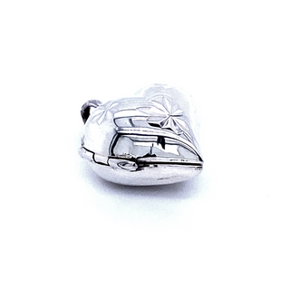 A delicate etching adorns the surface of a Small Heart Shaped Locket with Star Etching from Super Silver, showcasing its silver beauty against a pristine white background.