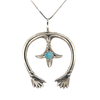 A Super Silver Native American Naja Pendant With Turquoise, perfect for adding a touch of southwest charm to any outfit.