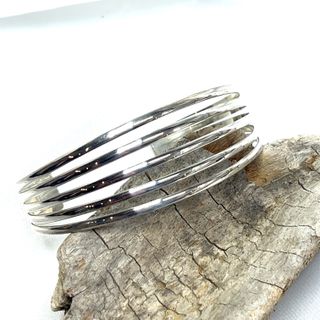 A modern chic Simple Cuff with Open Design sterling silver cuff bracelet on a piece of wood, by Super Silver.