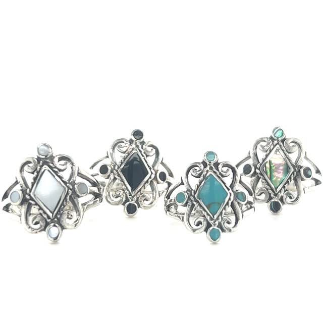 A collection of Victorian style inlay rings with blue and black stones.