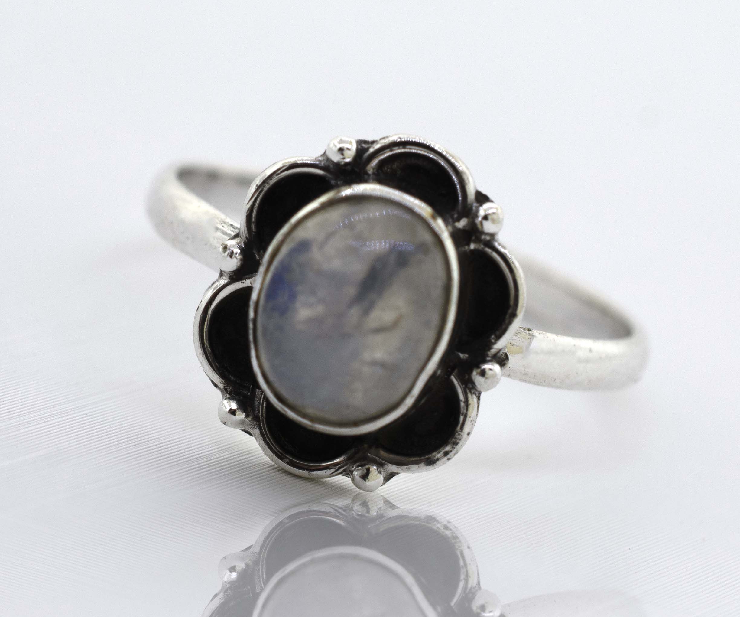 An exquisite Gemstone Ring With Oxidized Flower Design from Super Silver, with a central blue gemstone.