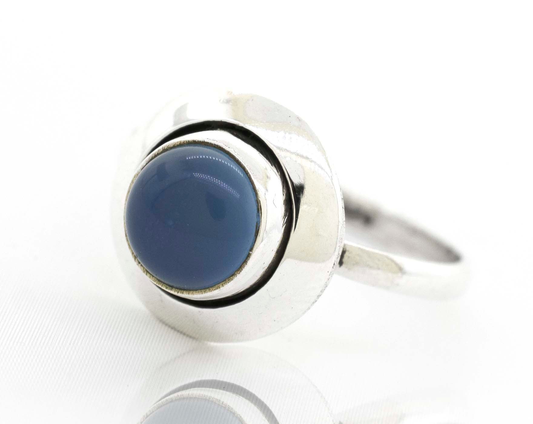 A boho-inspired Round Gemstone Ring With Oxidized Outline adorned with a stunning blue stone.