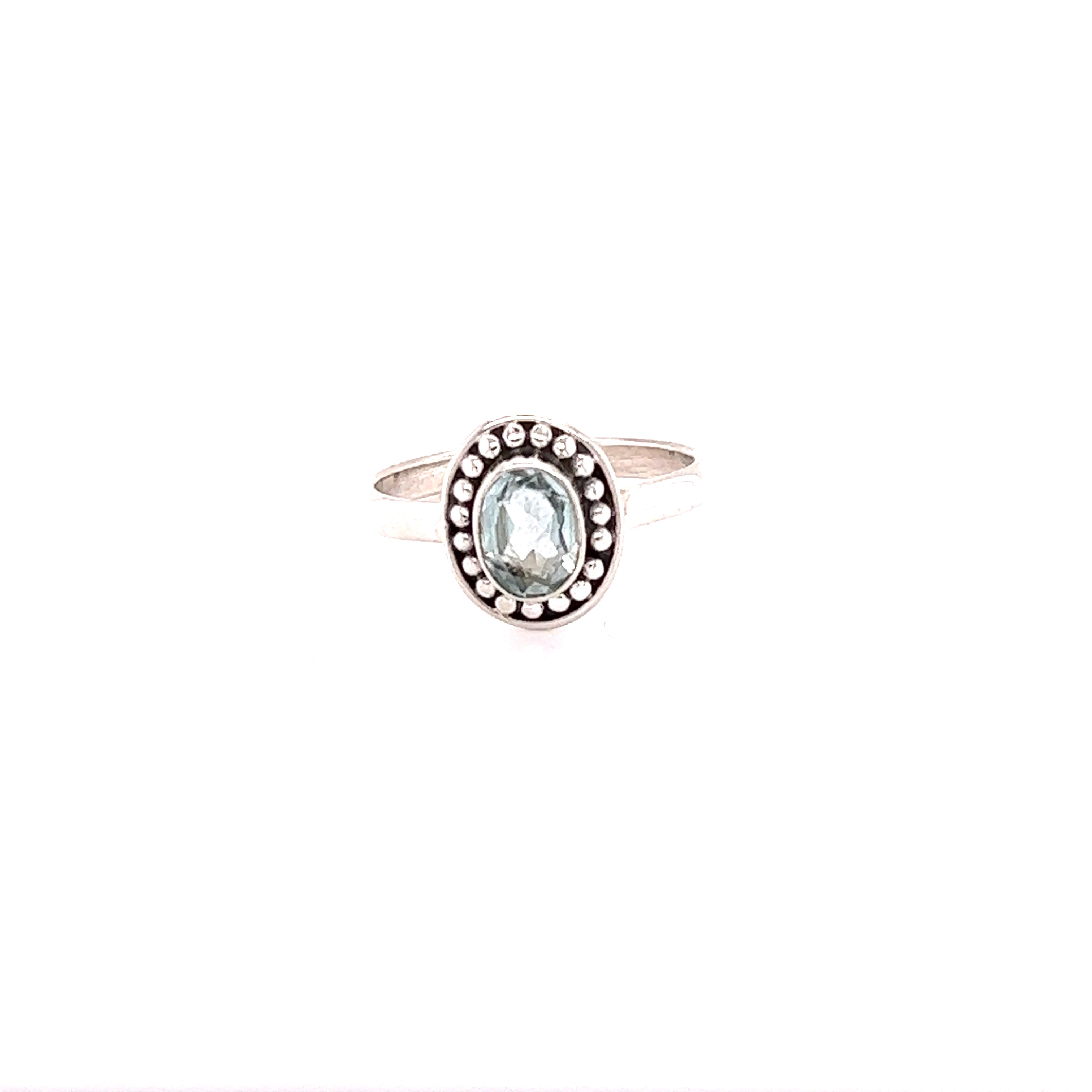 A oval gemstone ring with ball disk border.