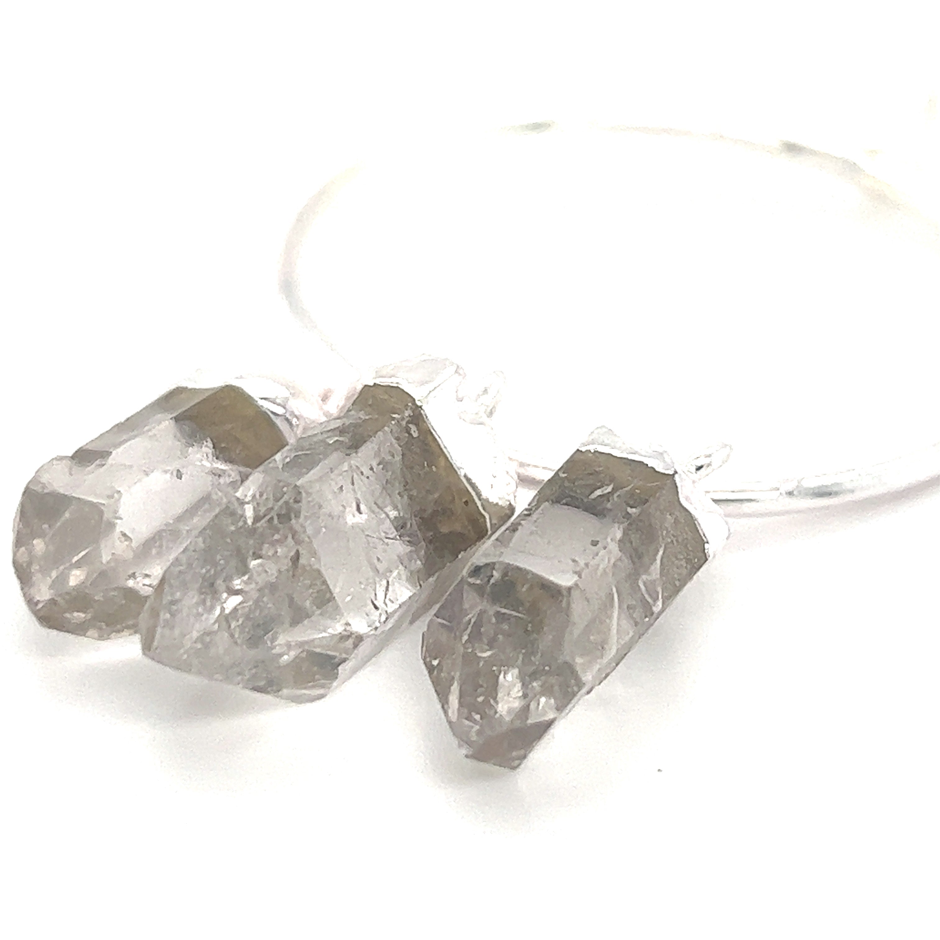 A simple and versatile everyday accessory featuring three earthy Raw Quartz on Ring Pendants hanging delicately from a Super Silver hoop, perfect for layering with other pieces.
