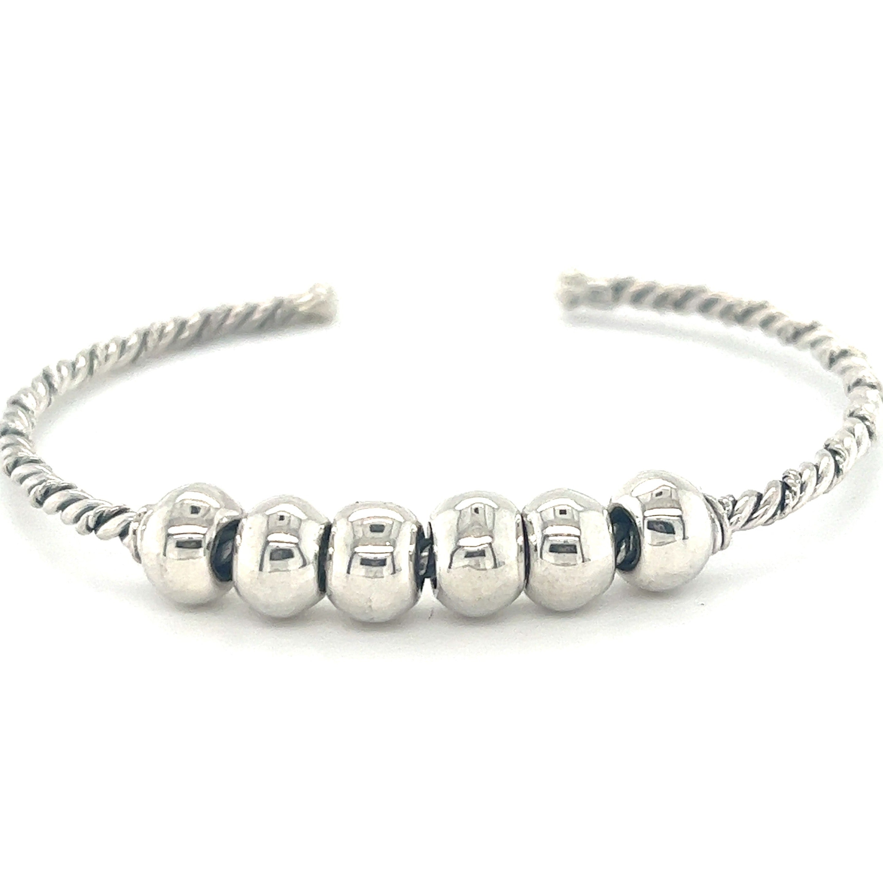 A Handmade Twisted Cuff with Balls featuring a twisted band with five polished round beads aligned in the center, evoking an antique look.